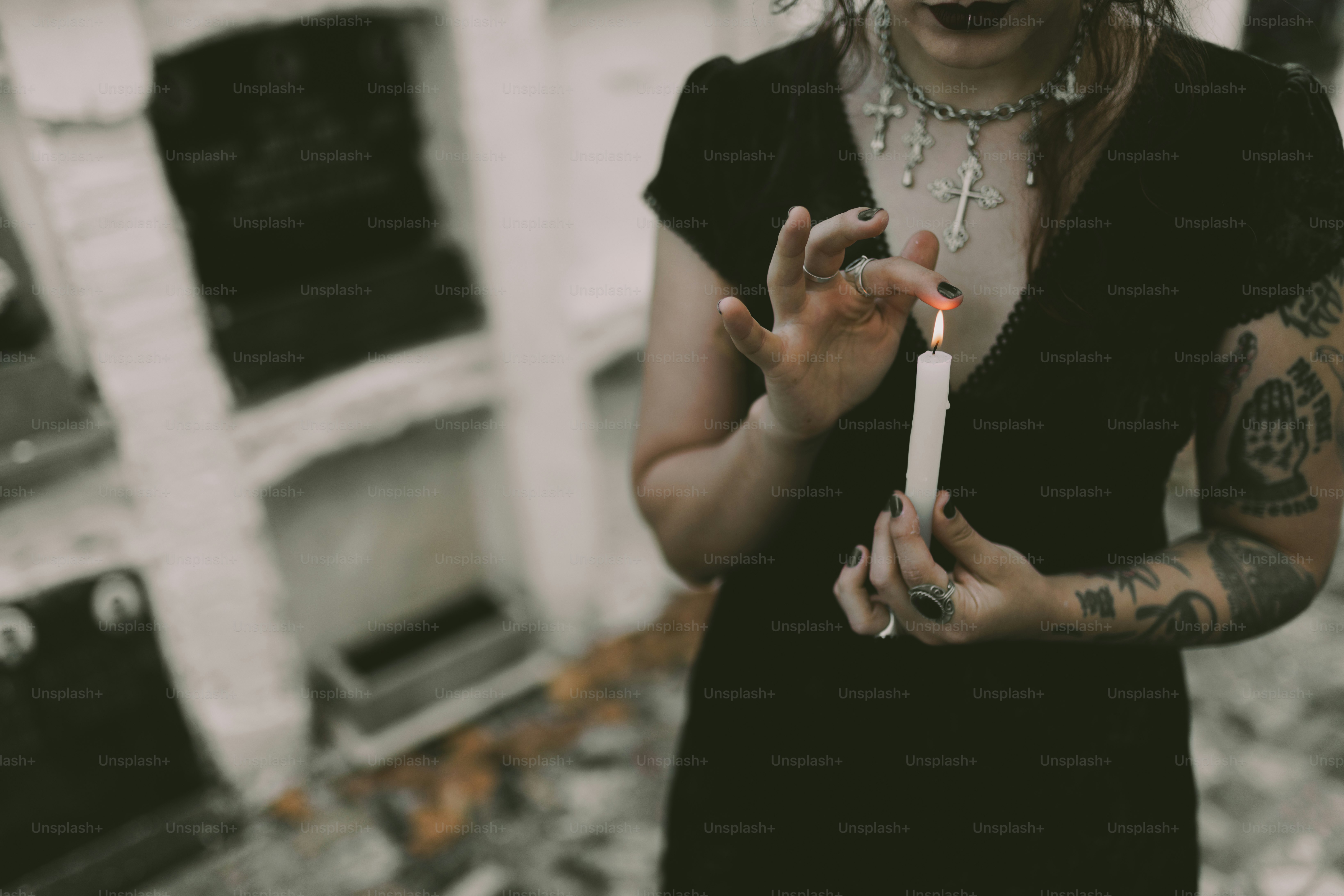 Woman in black holds a candle.