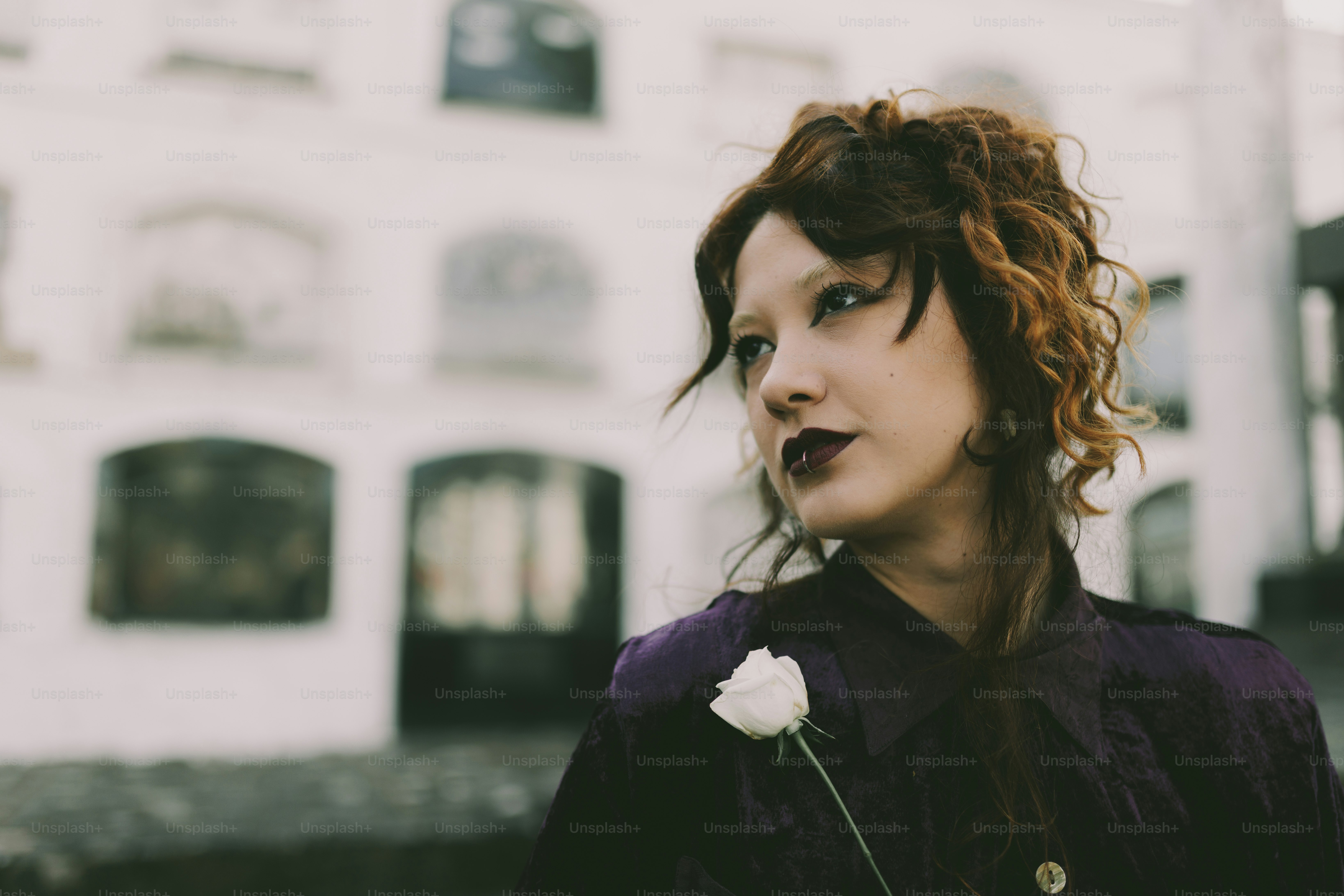 建物の前でポーズをとる白いバラの女性。