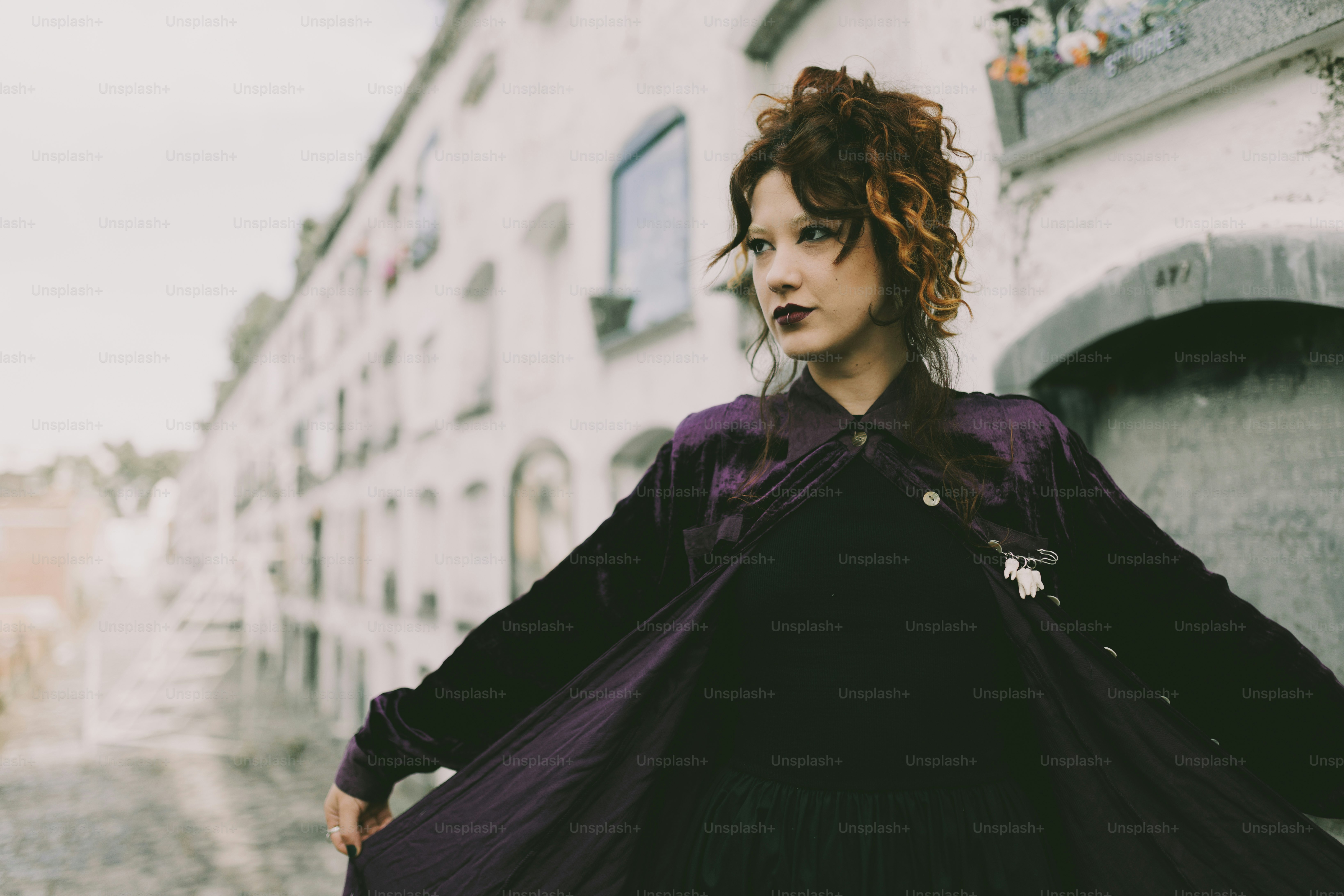 紫色のドレスを着た女性が屋外でポーズをとっています。