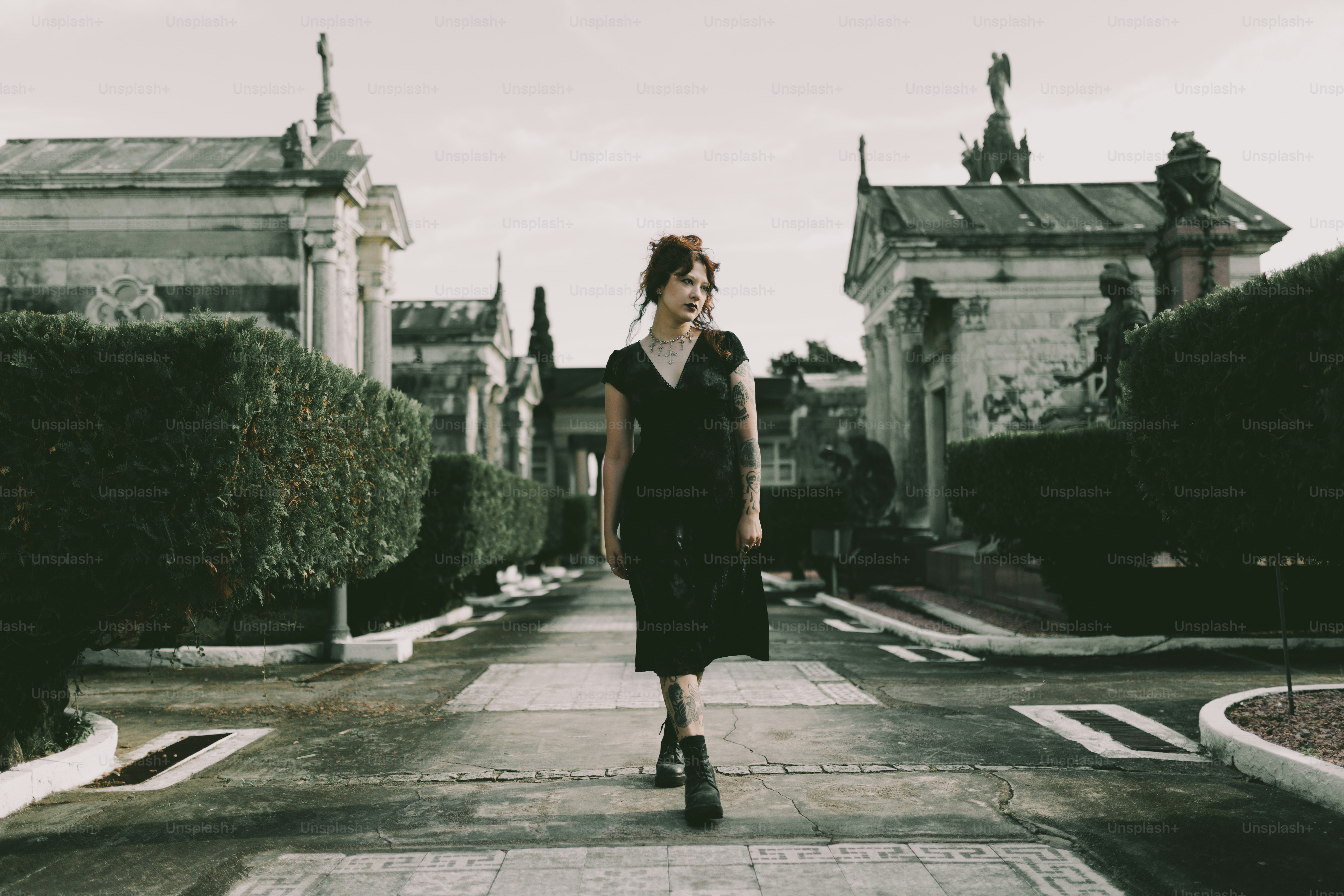 A woman walks alone through a cemetery.
