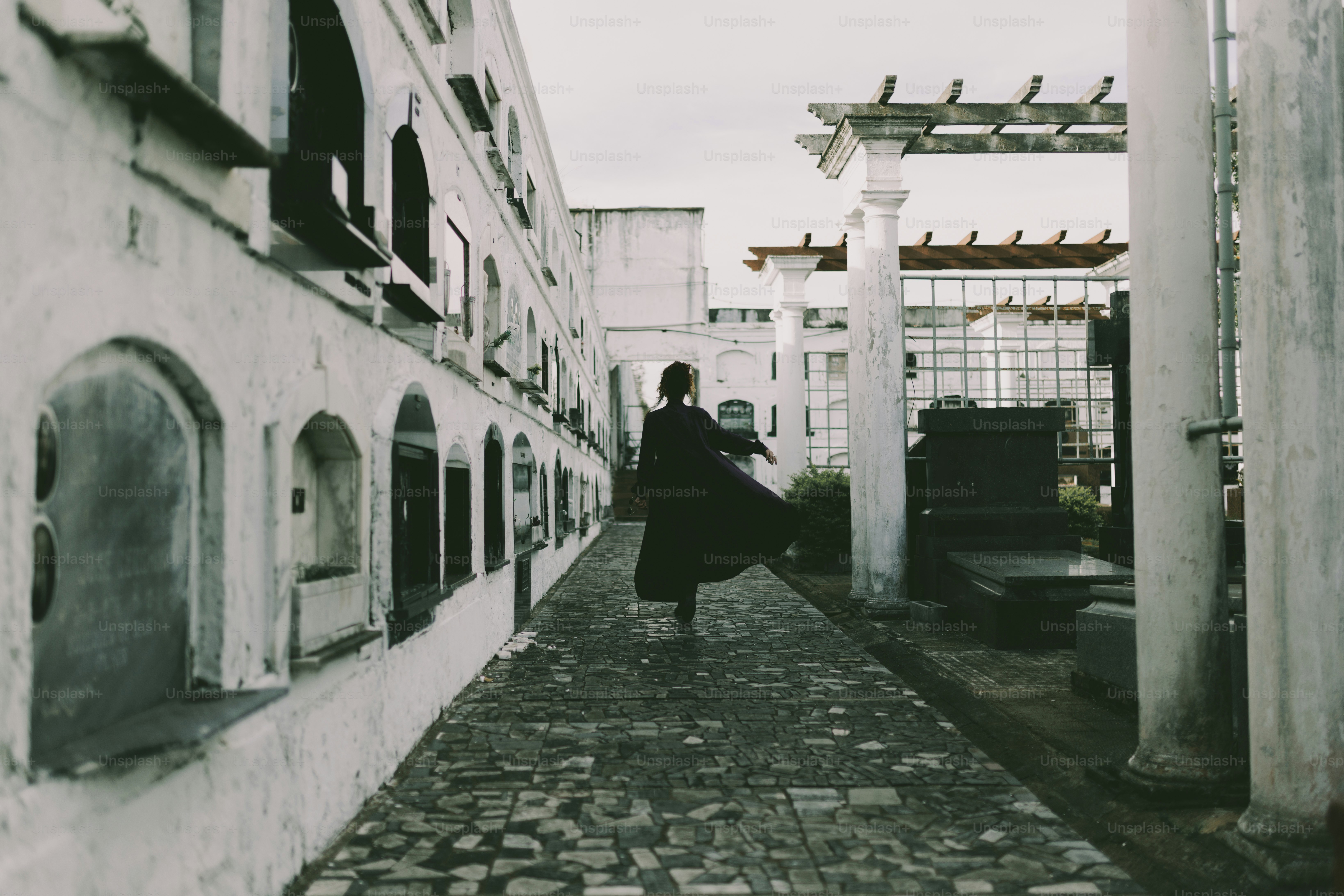 Woman dances down a stone walkway.
