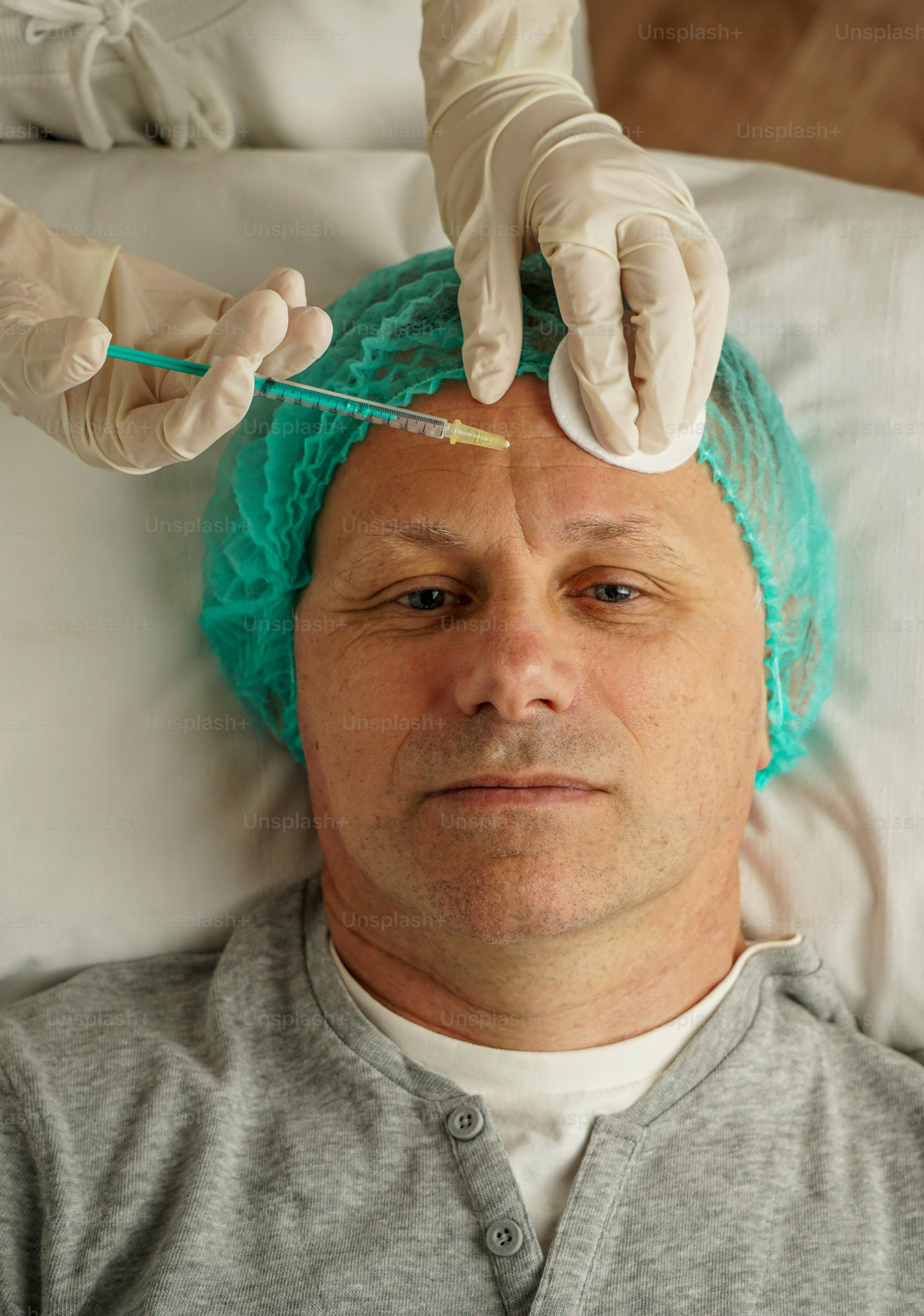 Un uomo sta ricevendo un'iniezione di botox sulla fronte.