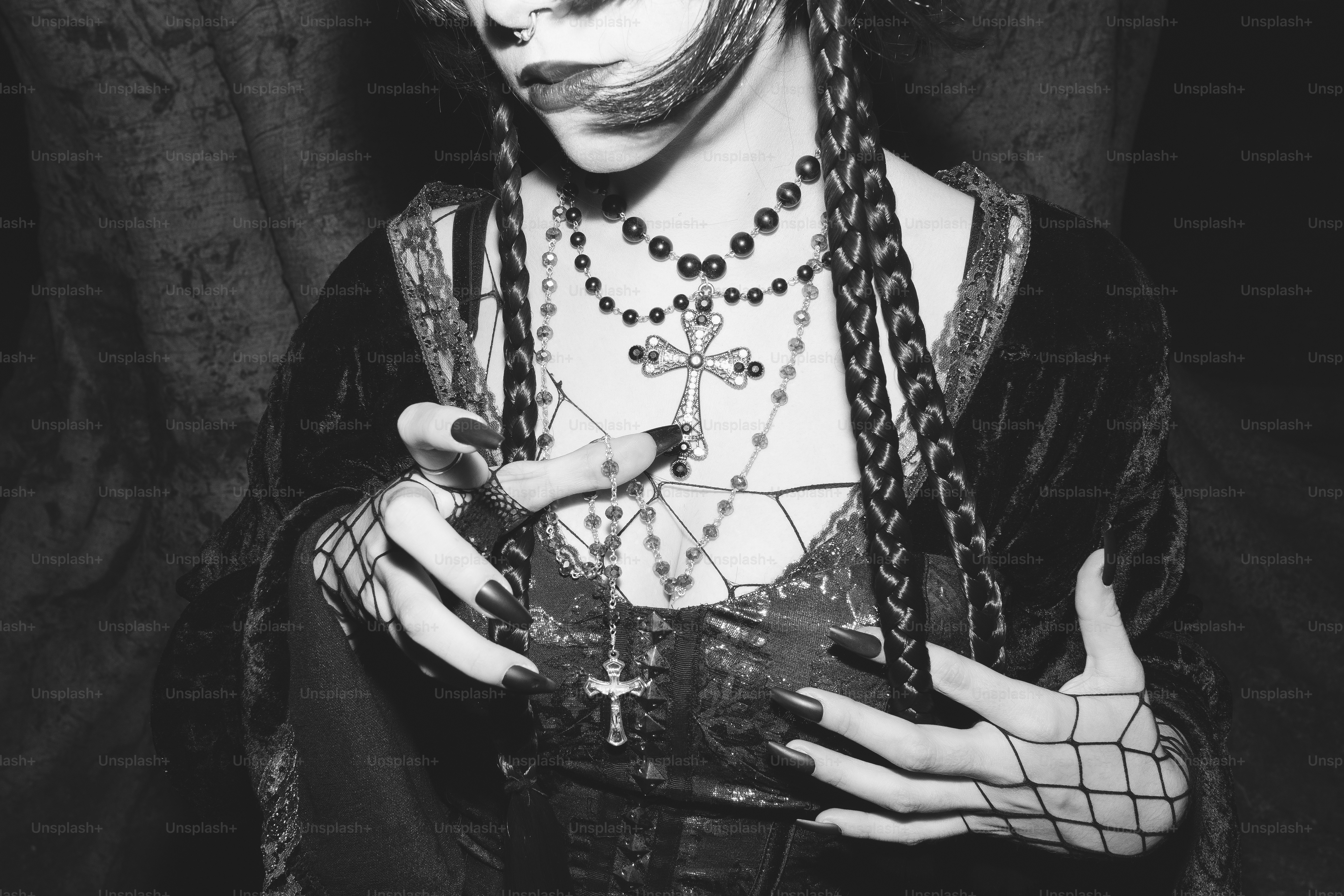 A gothic figure with jewelry gestures towards you.