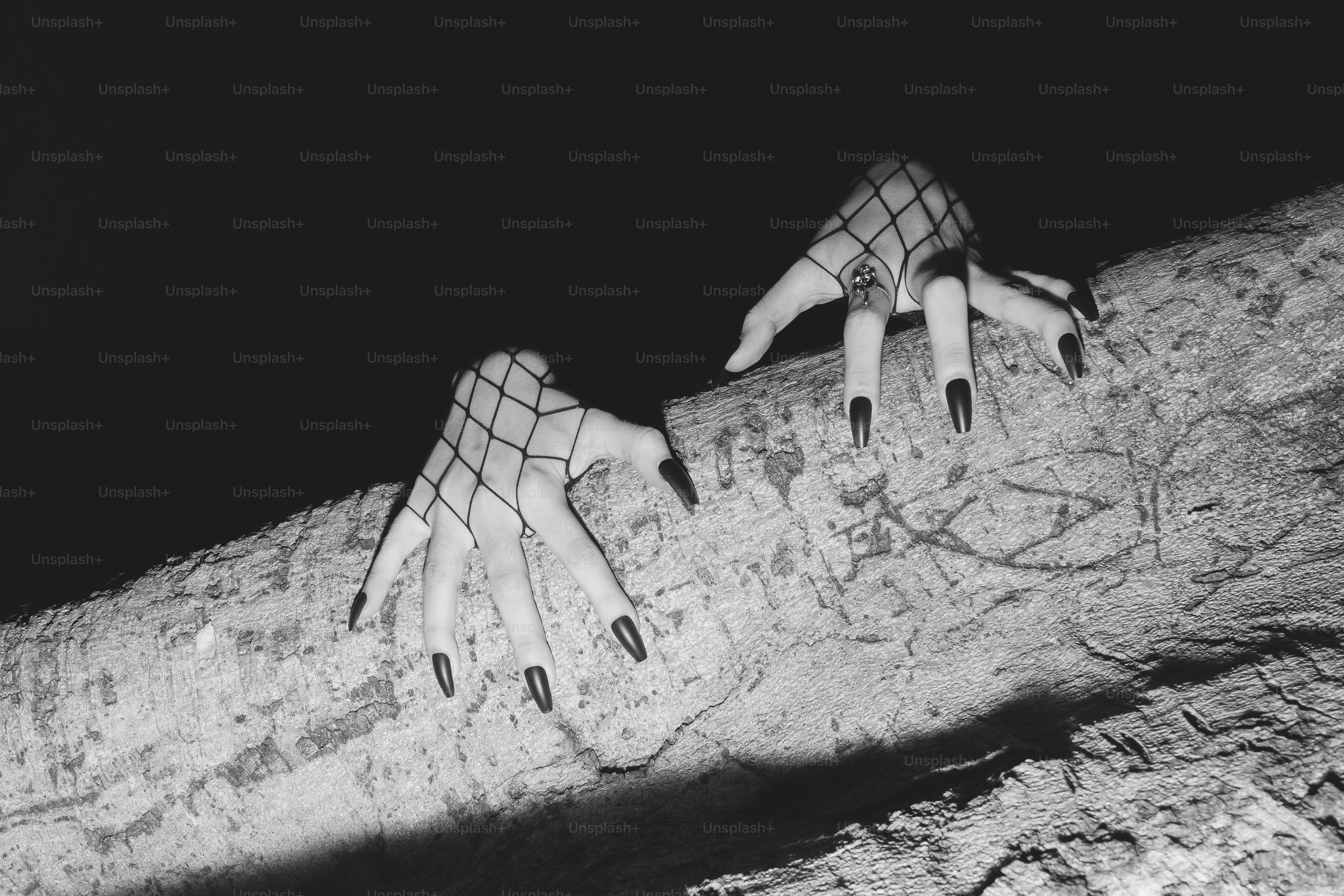Clawed hands grip a tree branch in the darkness.