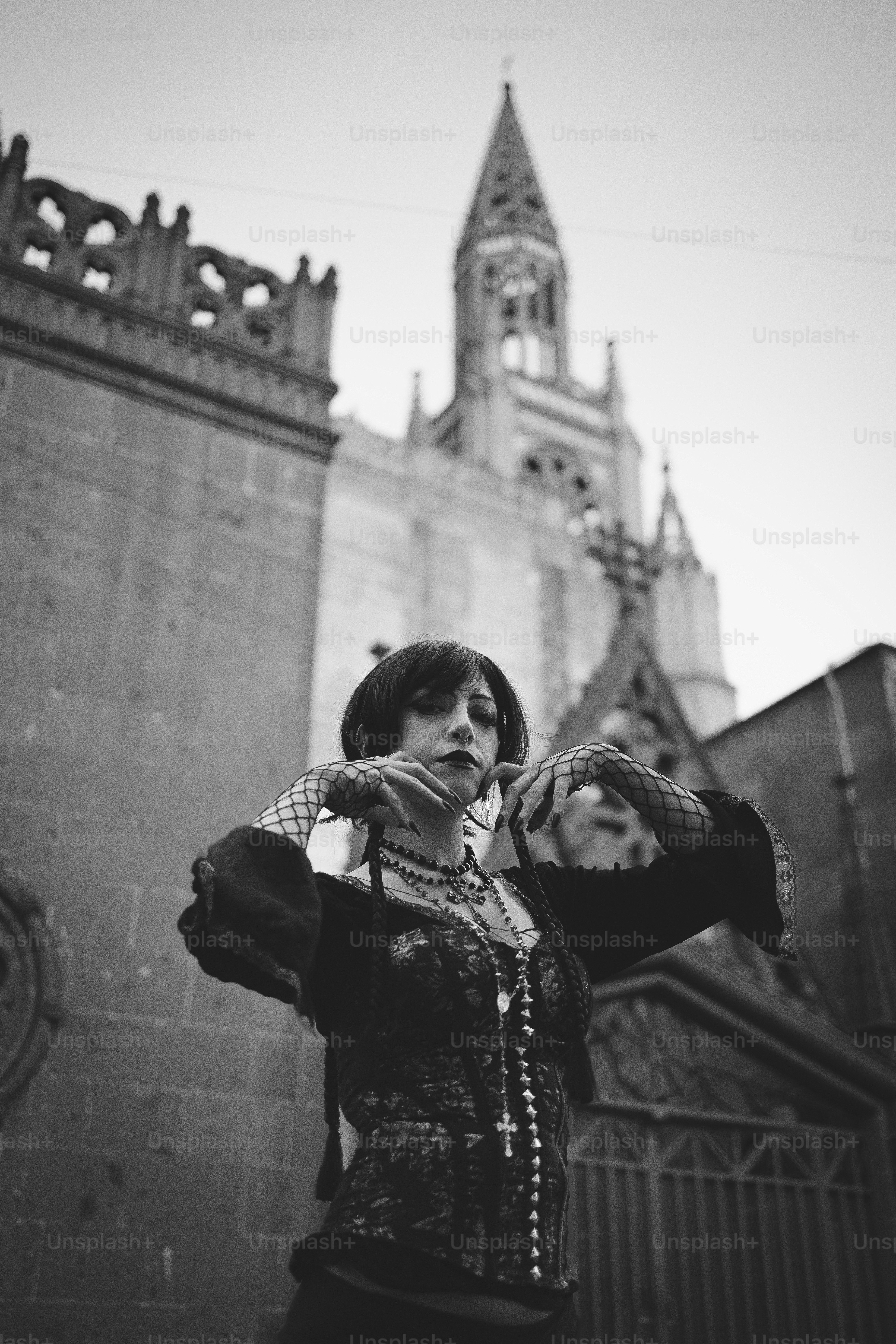 A gothic woman poses in front of a church.