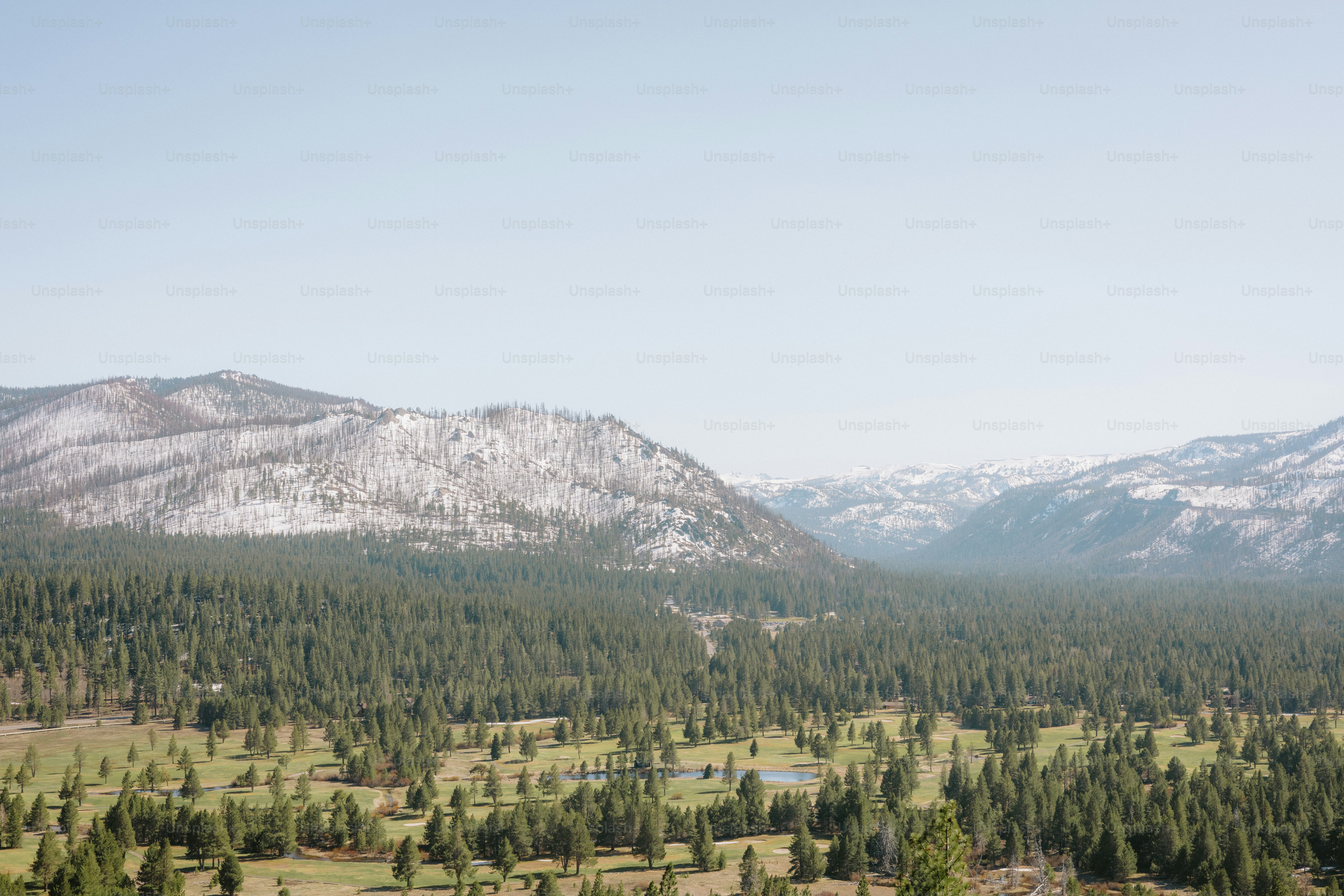 A scenic landscape featuring mountains, trees, and sky.