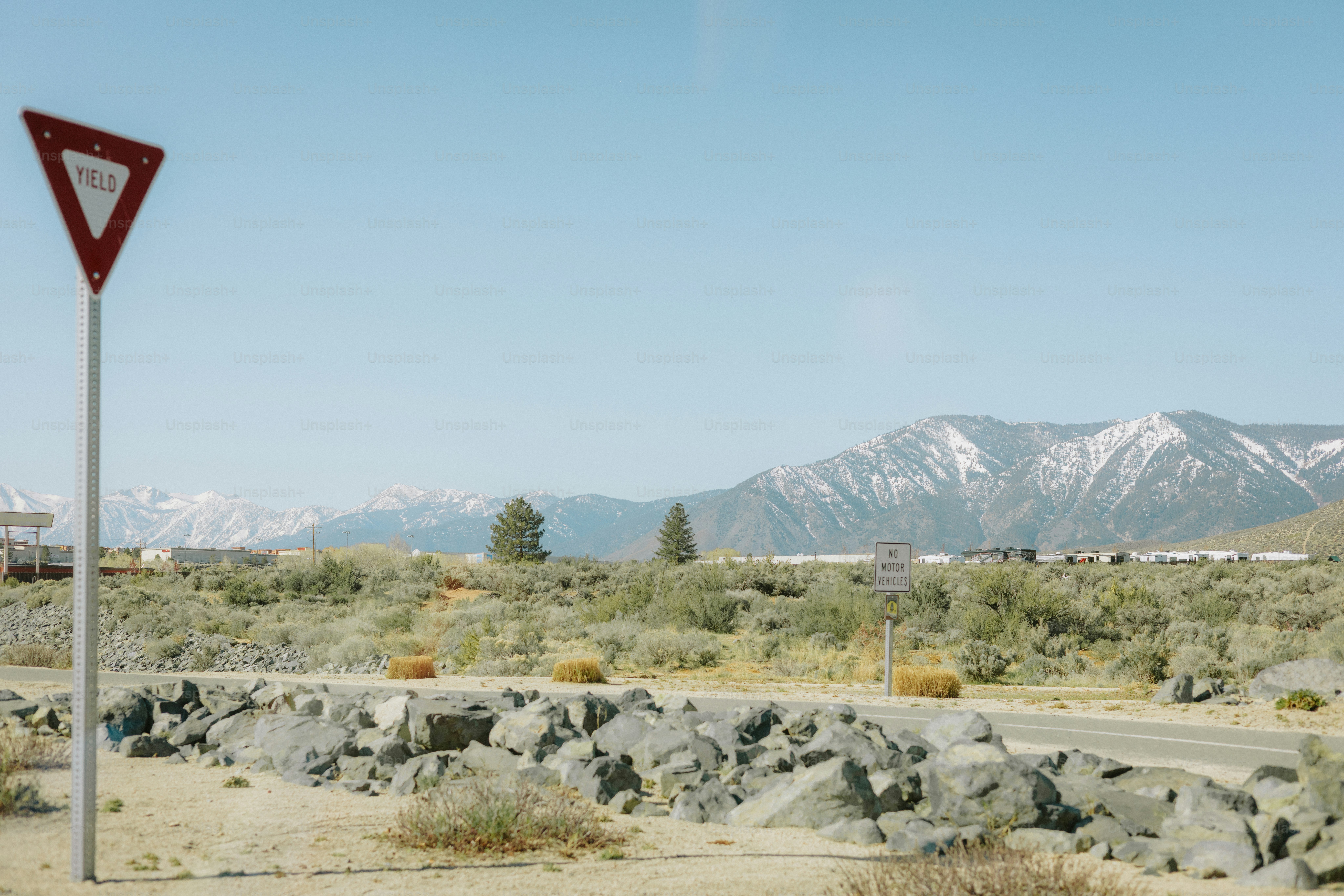 Yield sign overlooking a mountainous landscape. photo – Mountains Image ...