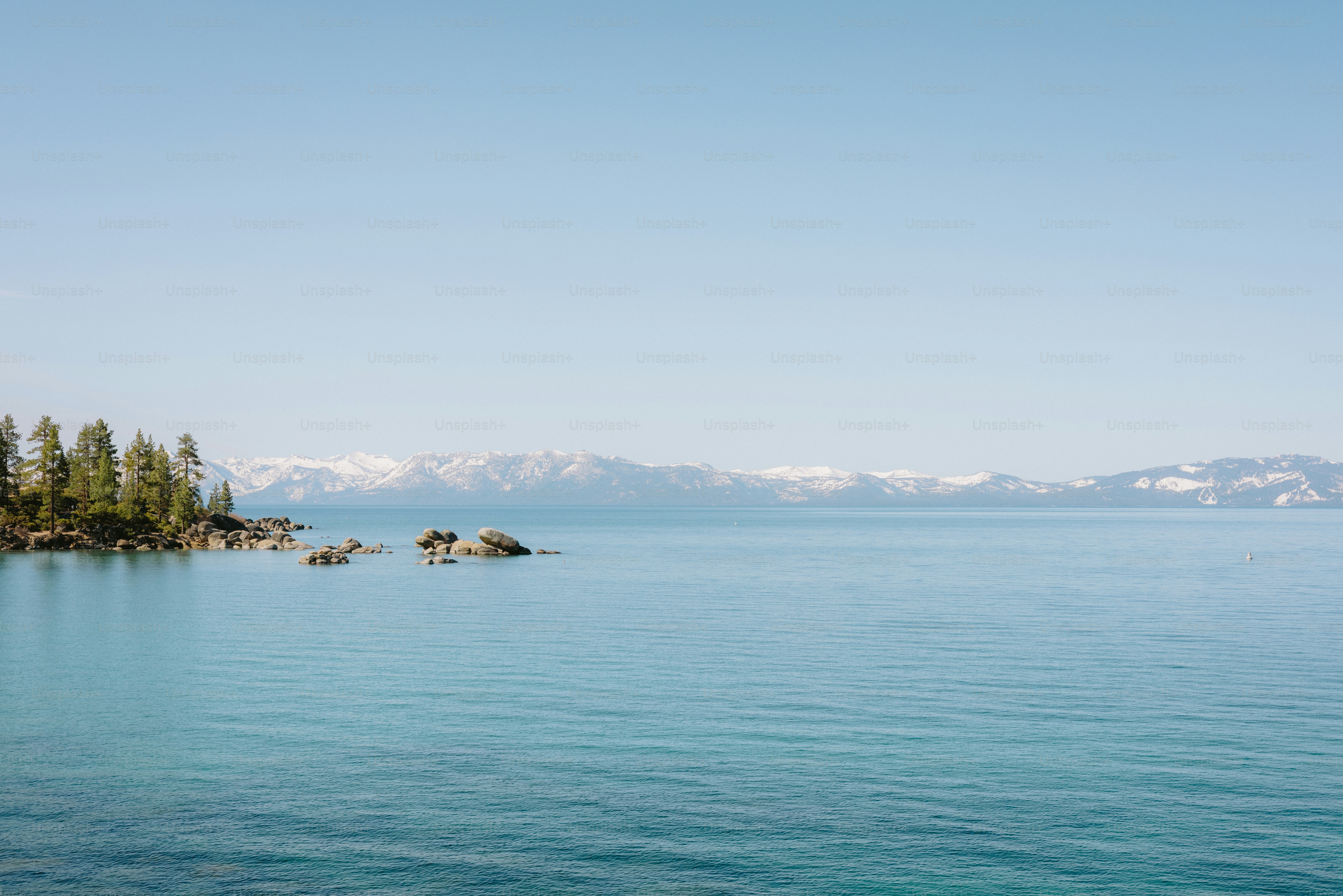 Blue water and mountains under a bright blue sky.
