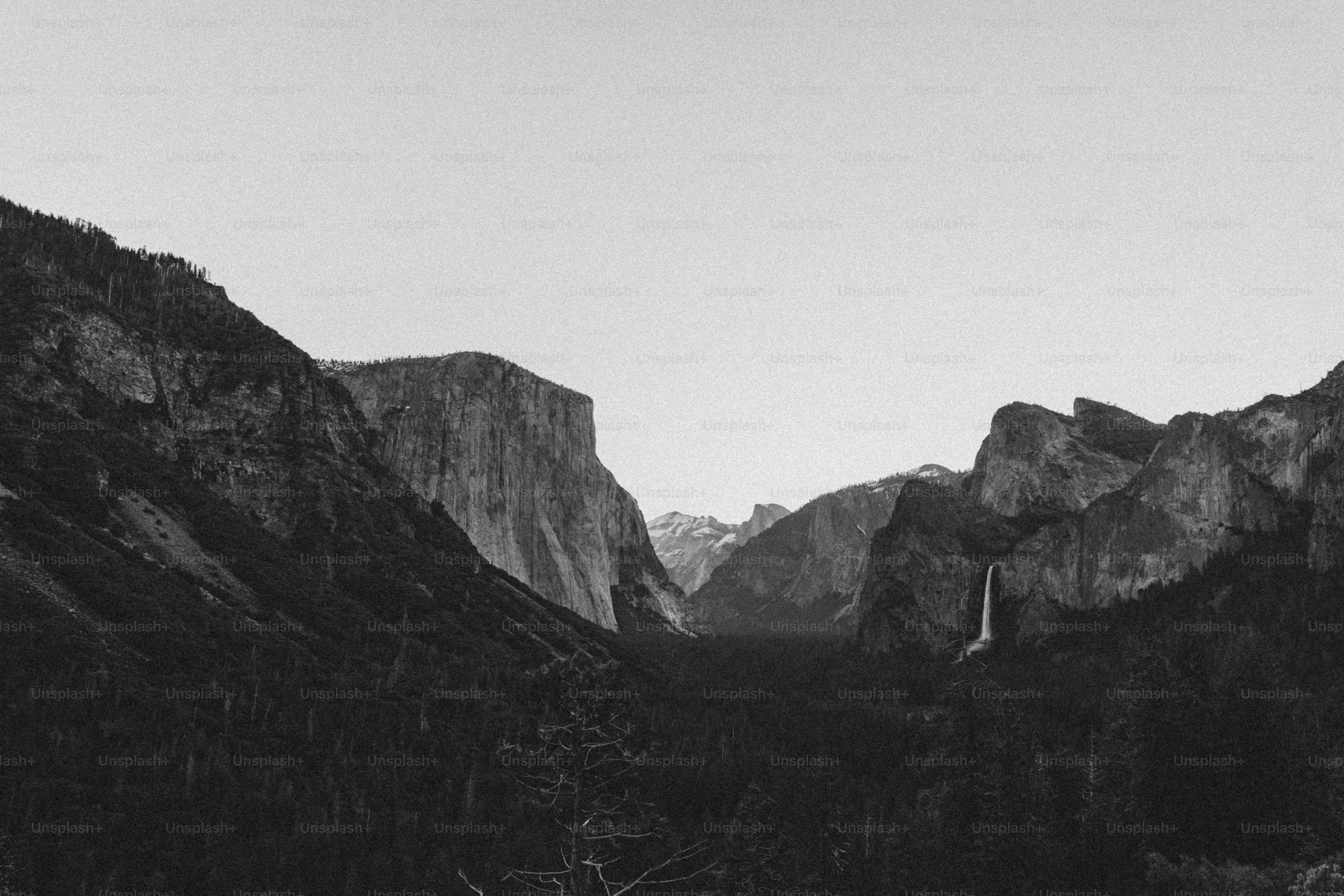 Mountains and a waterfall are visible in black and white.