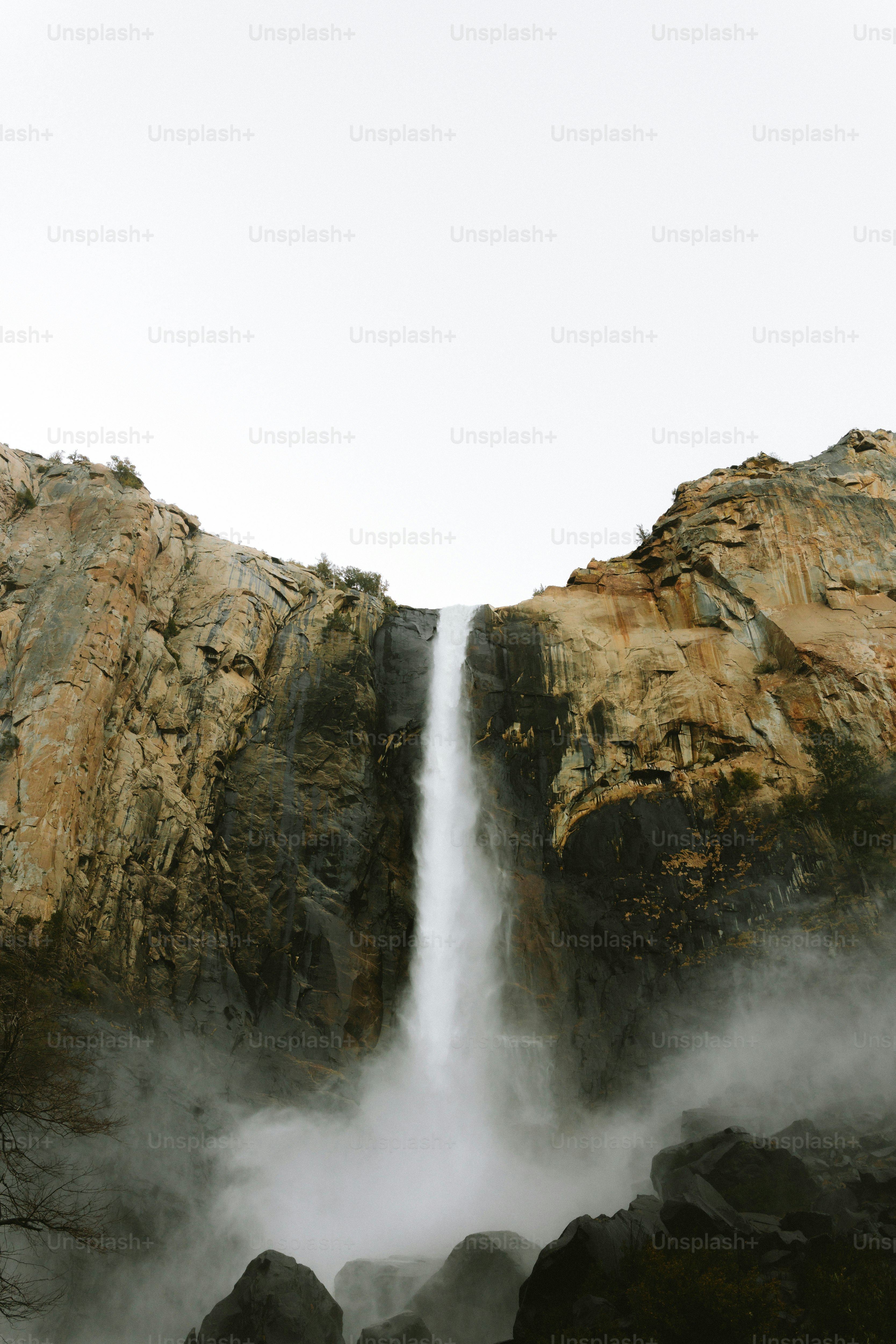 Waterfall cascades down a rugged, rocky cliff.