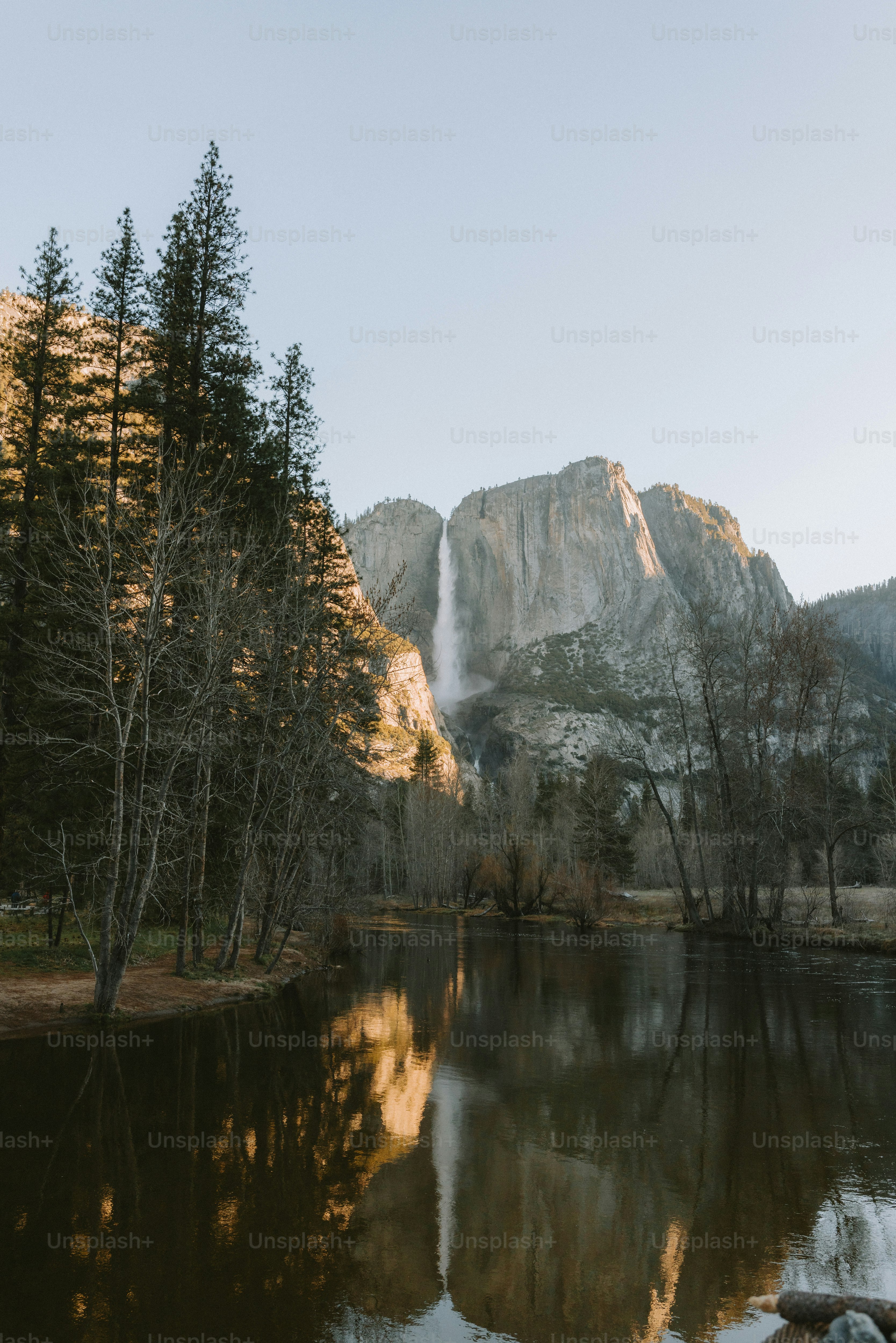 A waterfall reflects in a calm lake