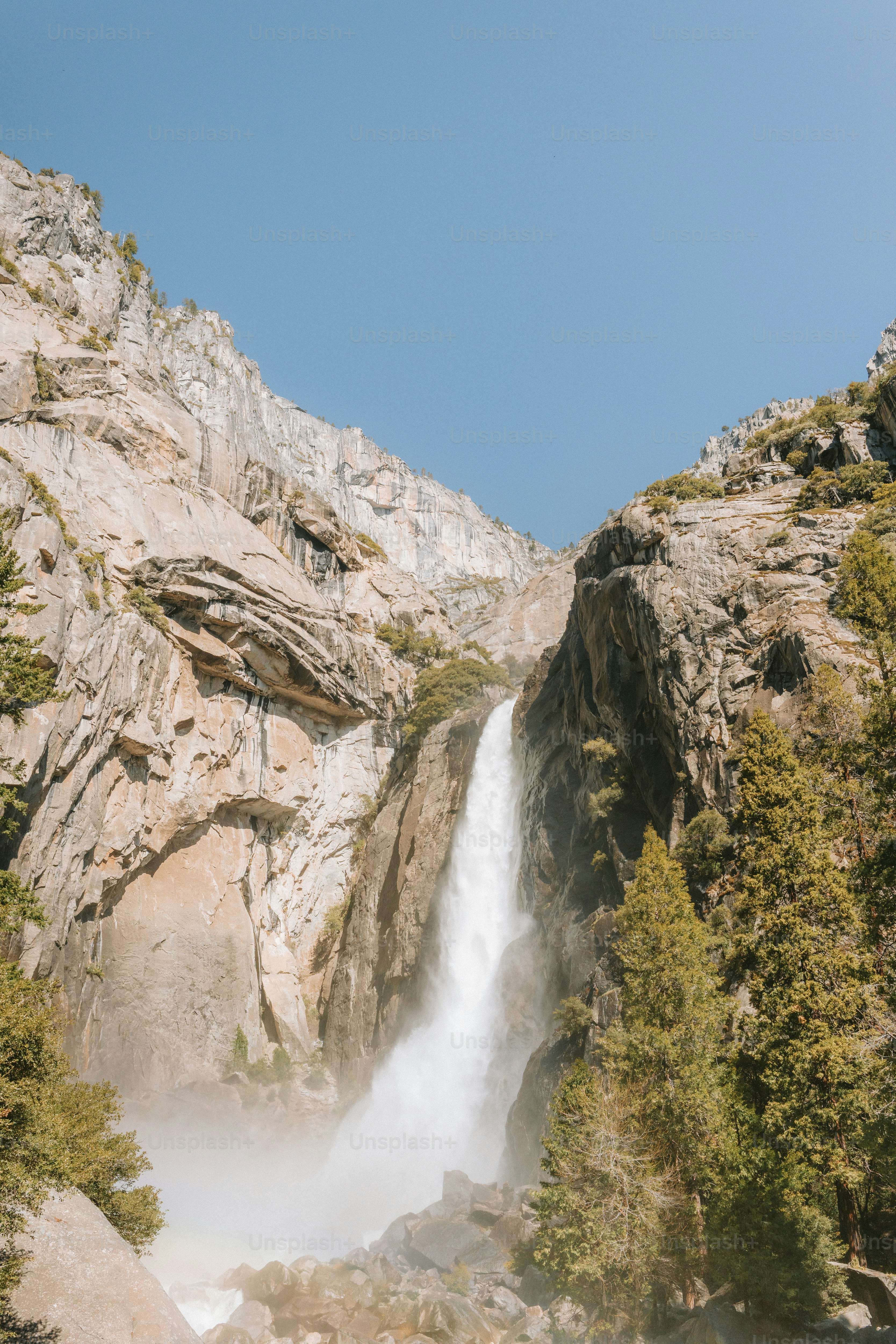 A tall waterfall cascades down a rocky mountain.