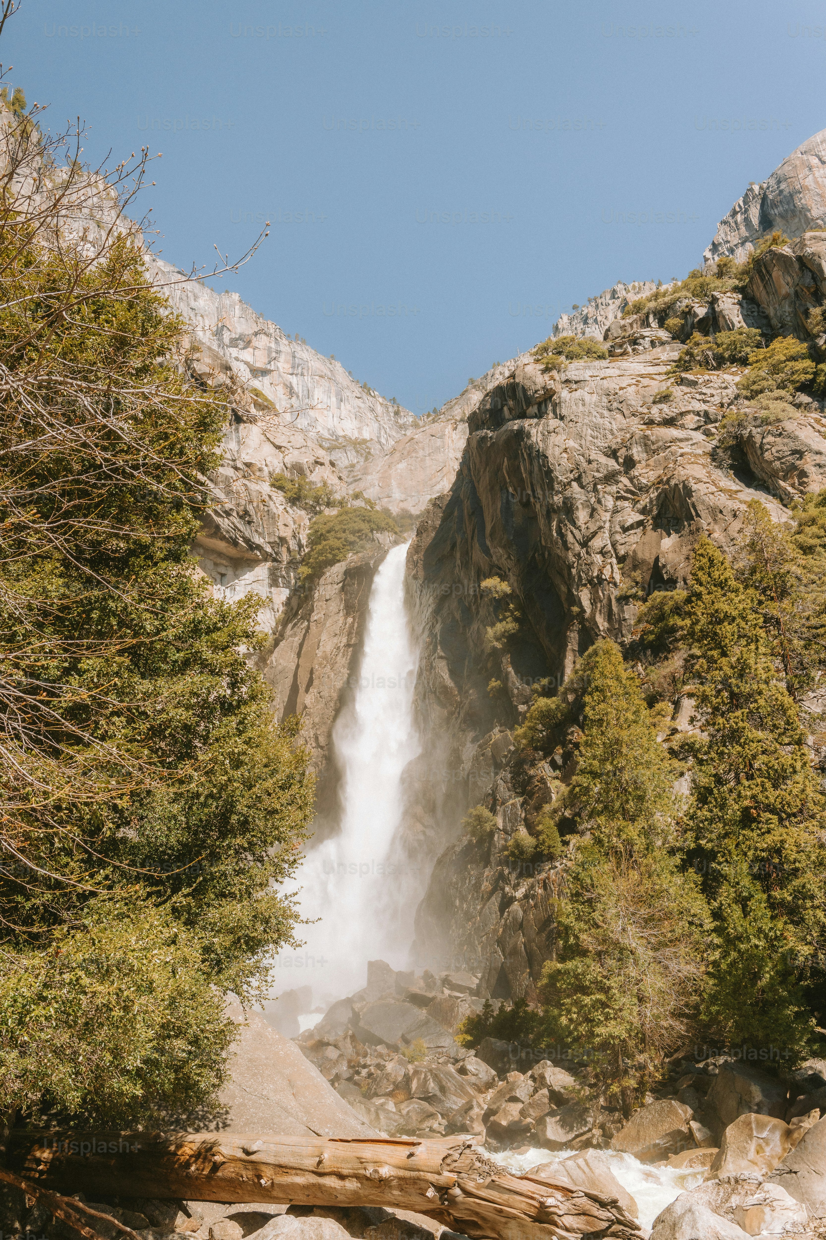 A majestic waterfall cascades between mountains.
