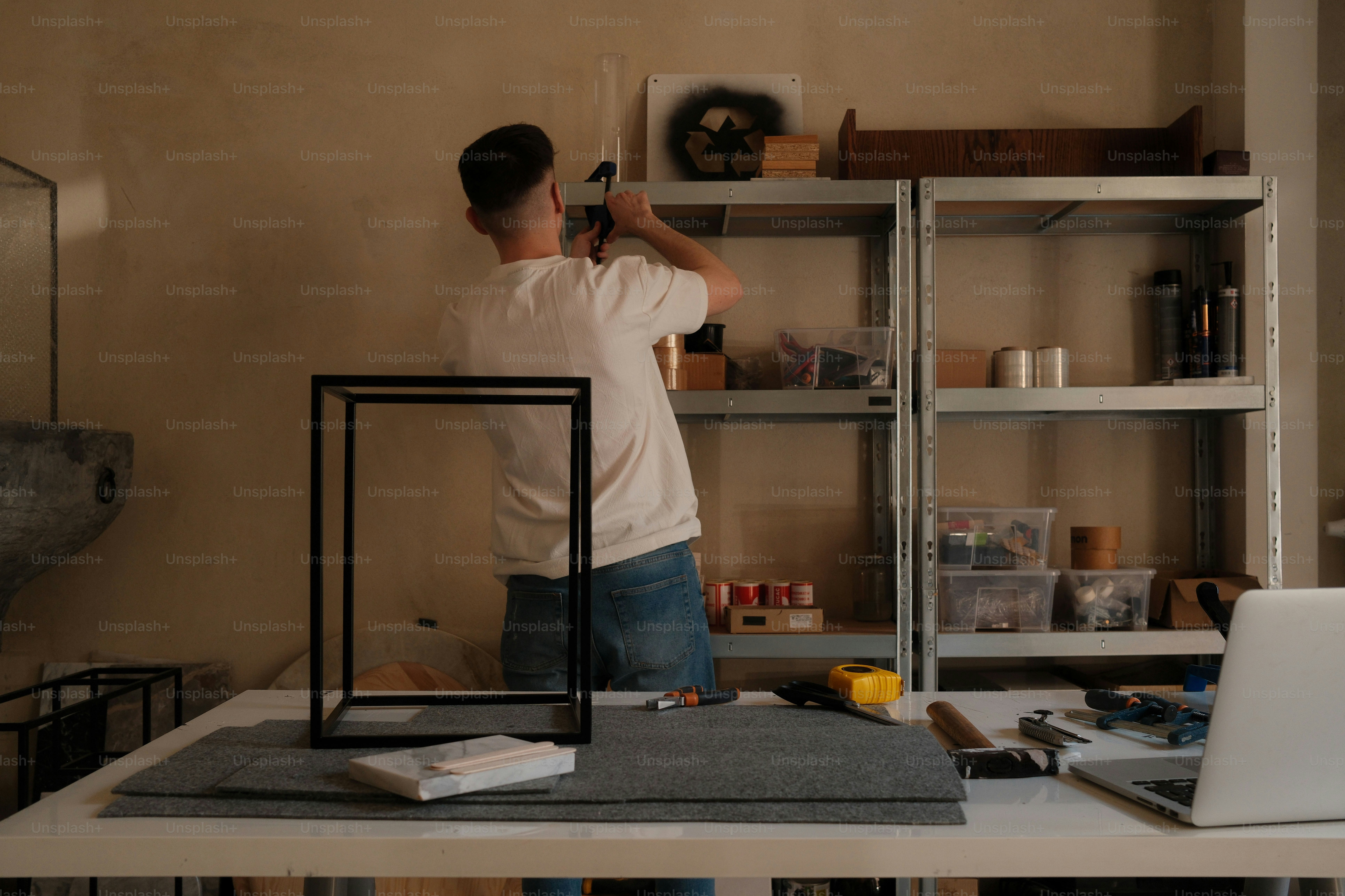A man is organizing shelves in a workshop