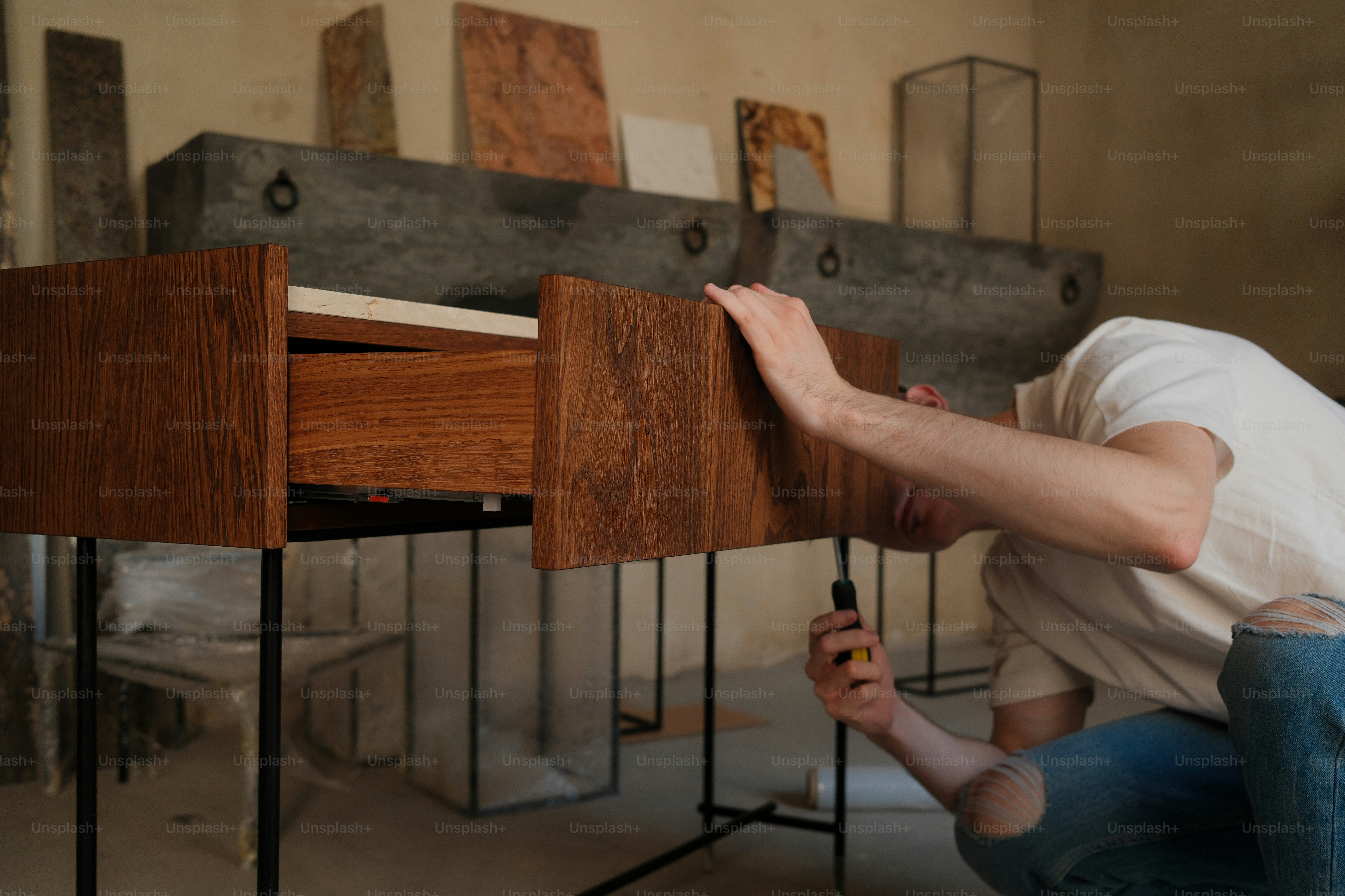 A person assembles furniture in a workshop.