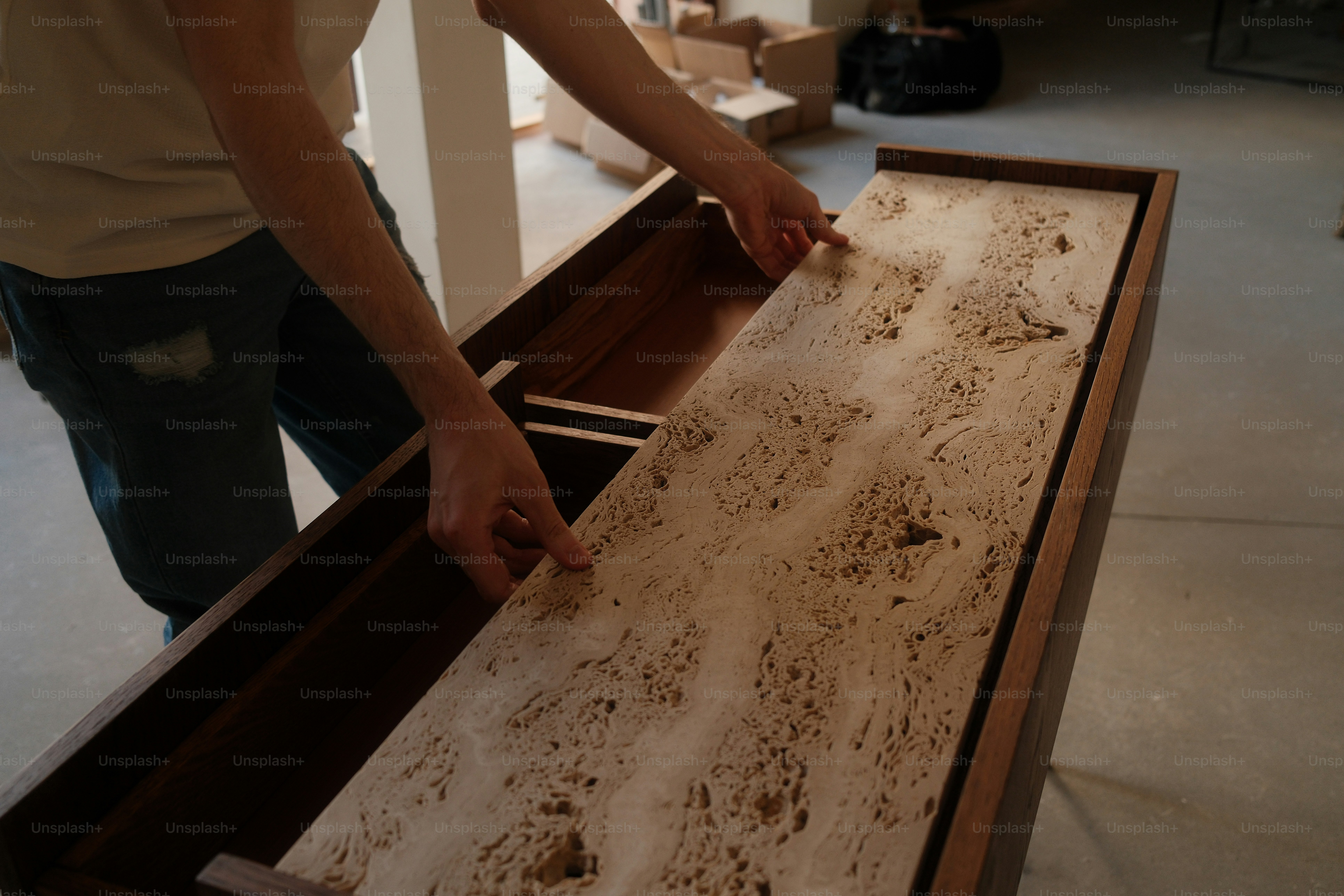 Person places wooden board inside a dark box.