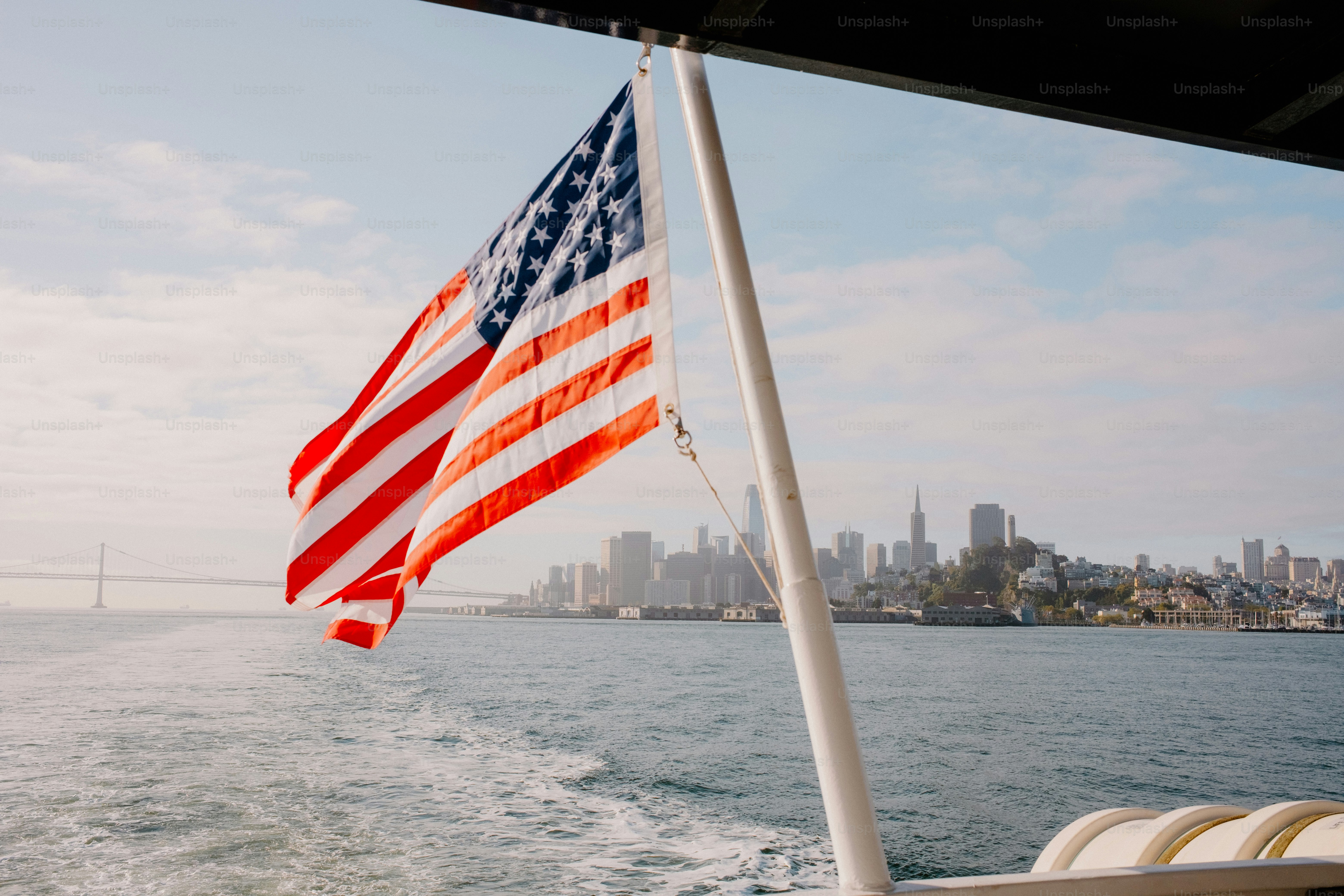 An american flag waves over a city's skyline