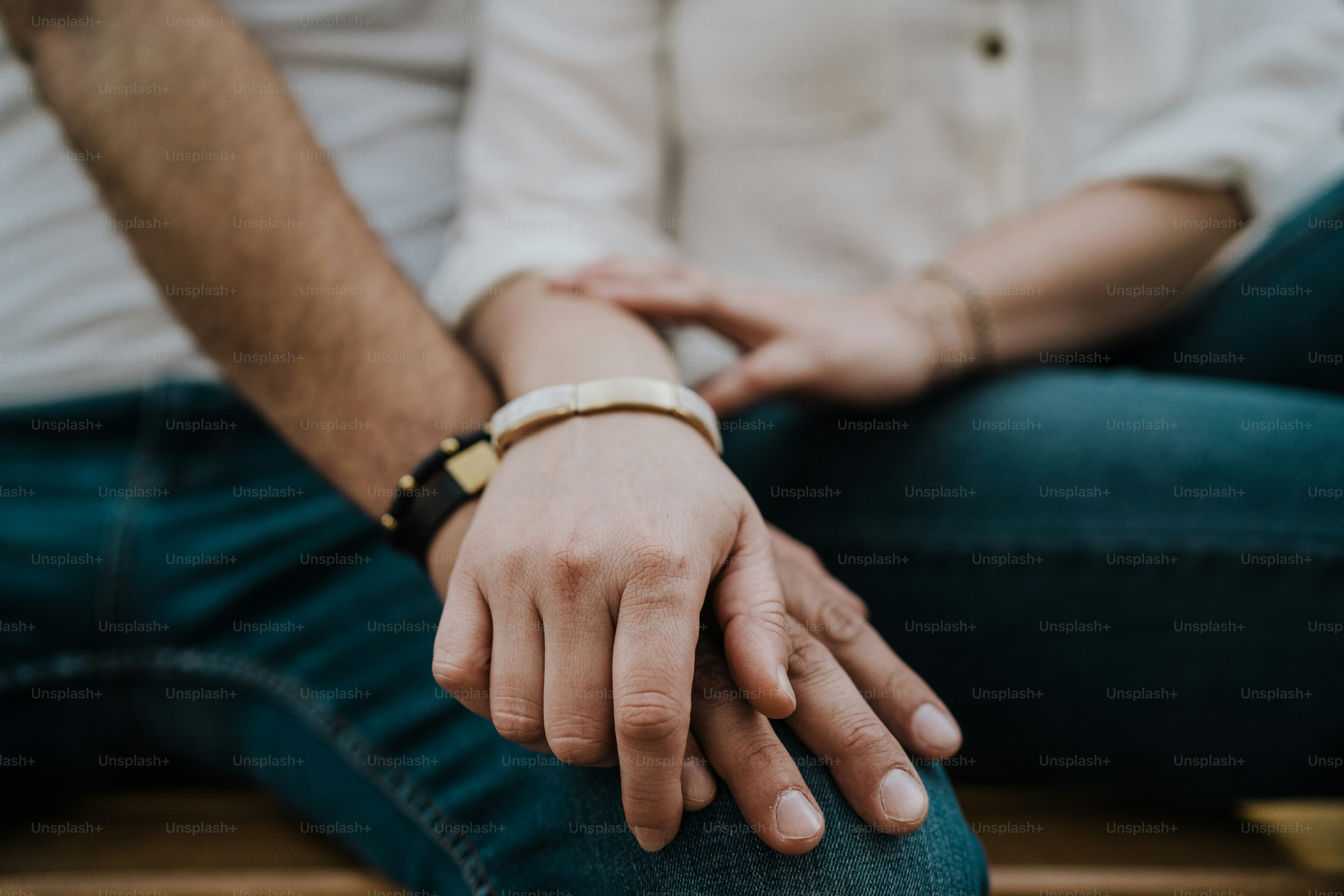 Two people hold hands and show affection.