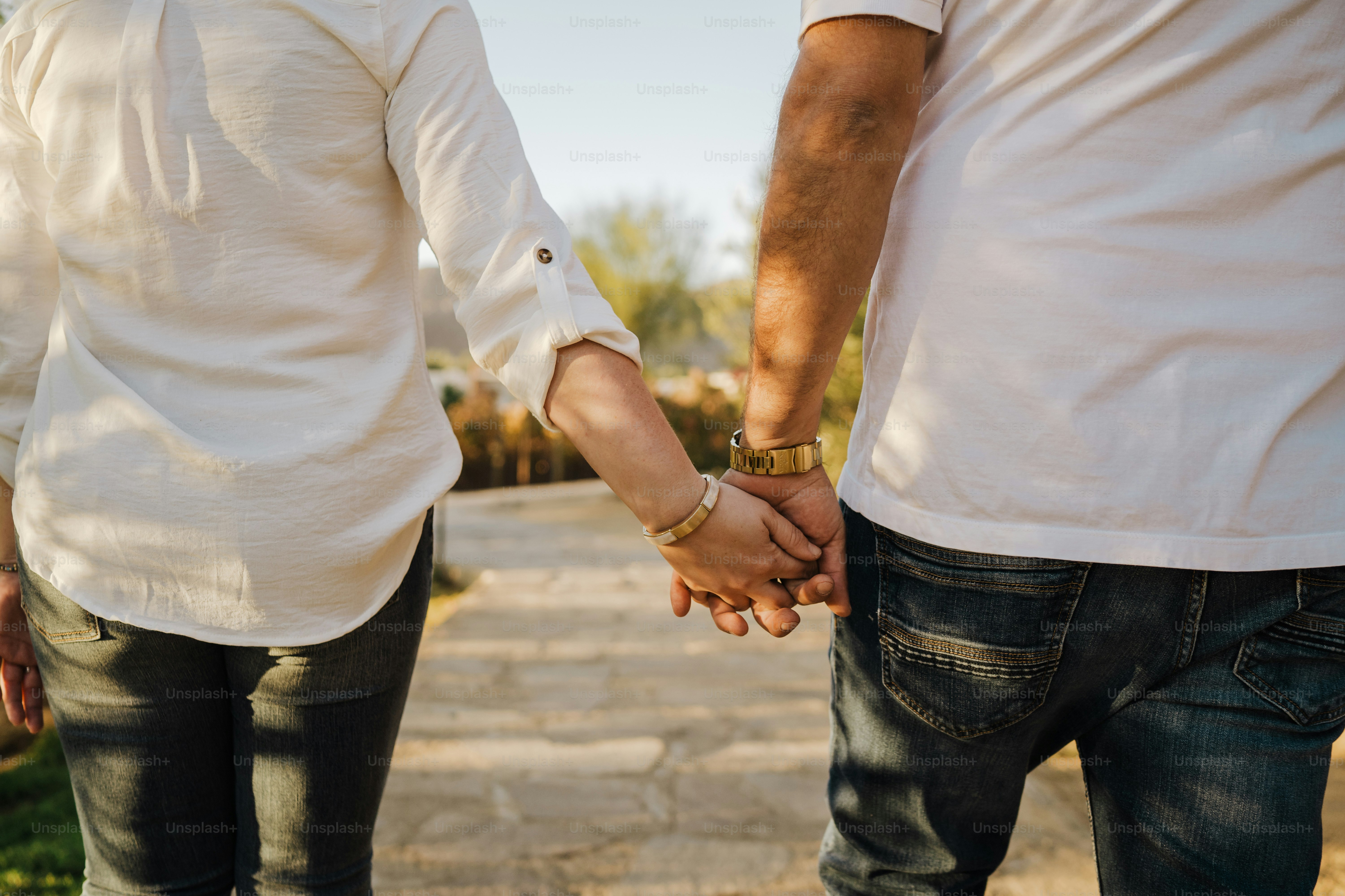 An elderly couple holds hands while walking.