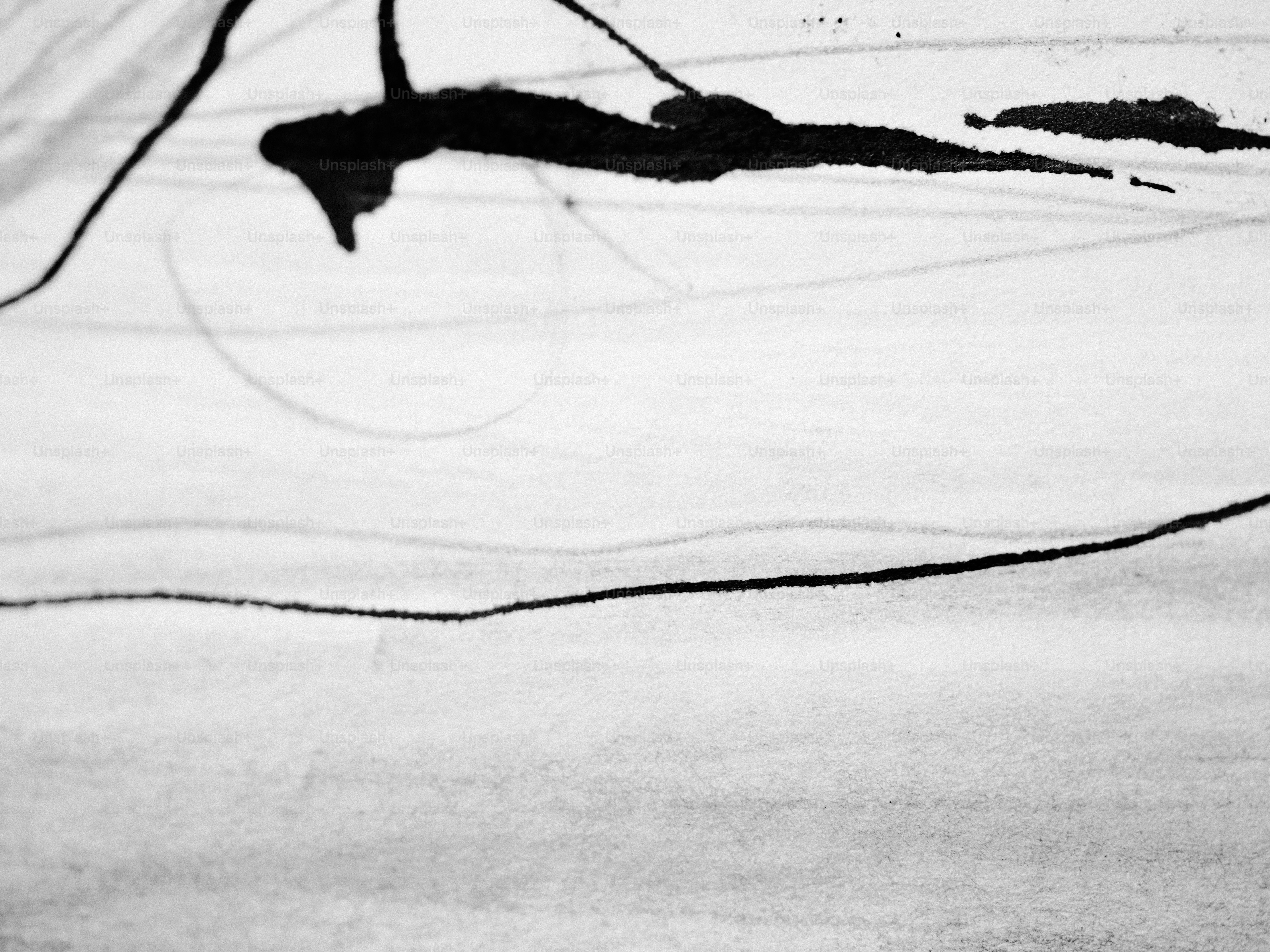 Black ink splatters and lines on a light background.