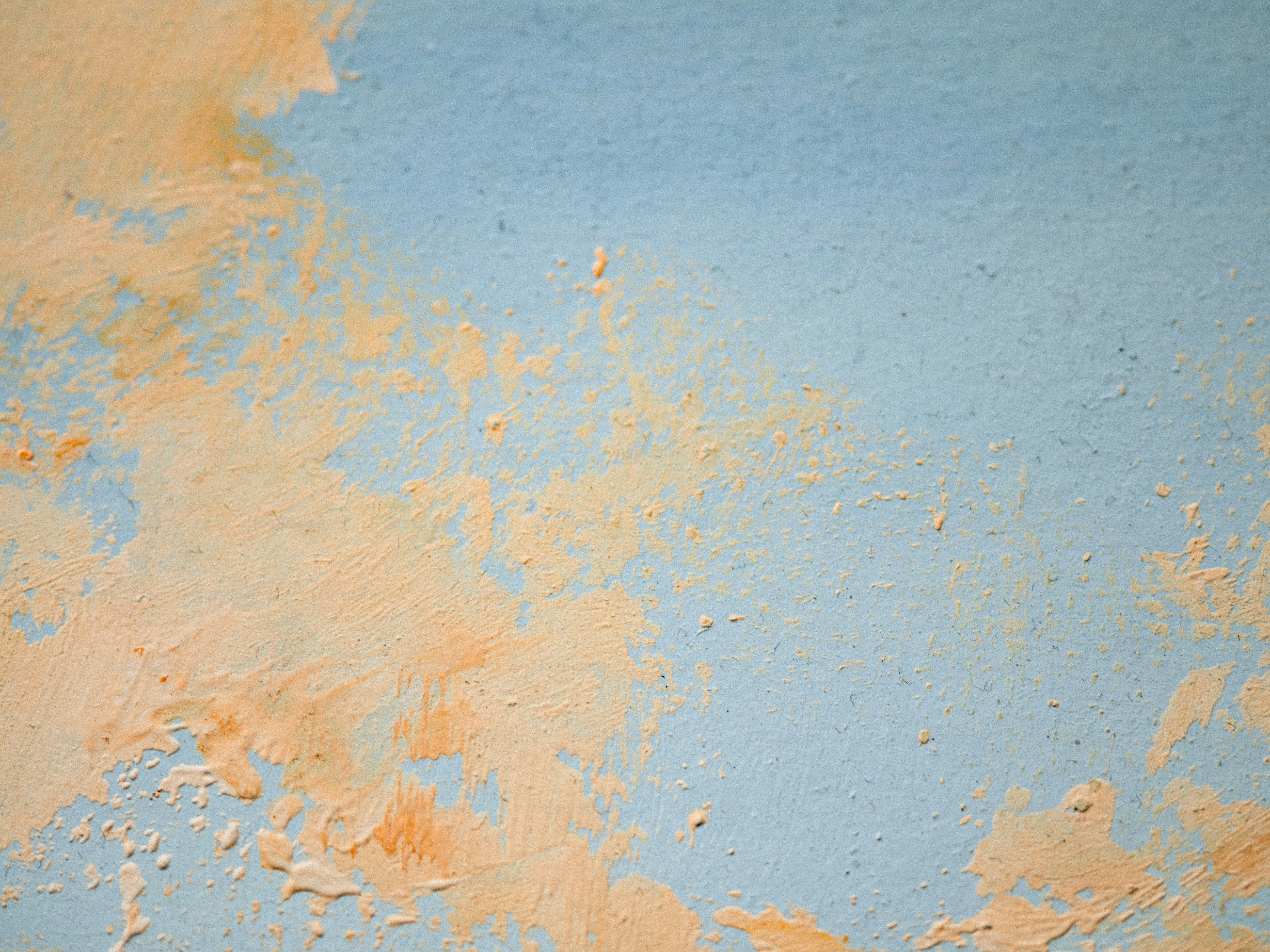 Orange paint stains a light blue wall.
