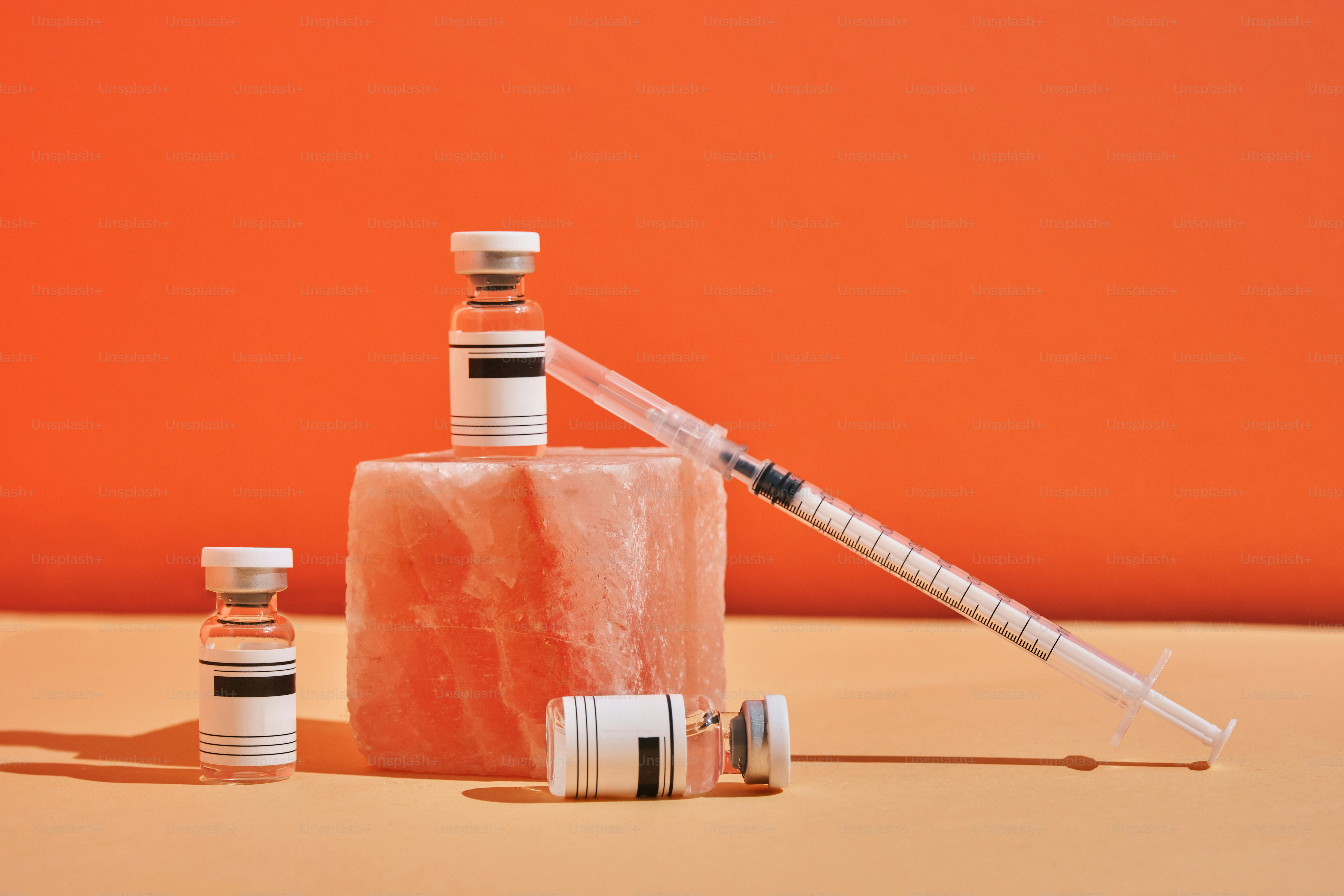 Vaccines and a syringe sit on a decorative block.