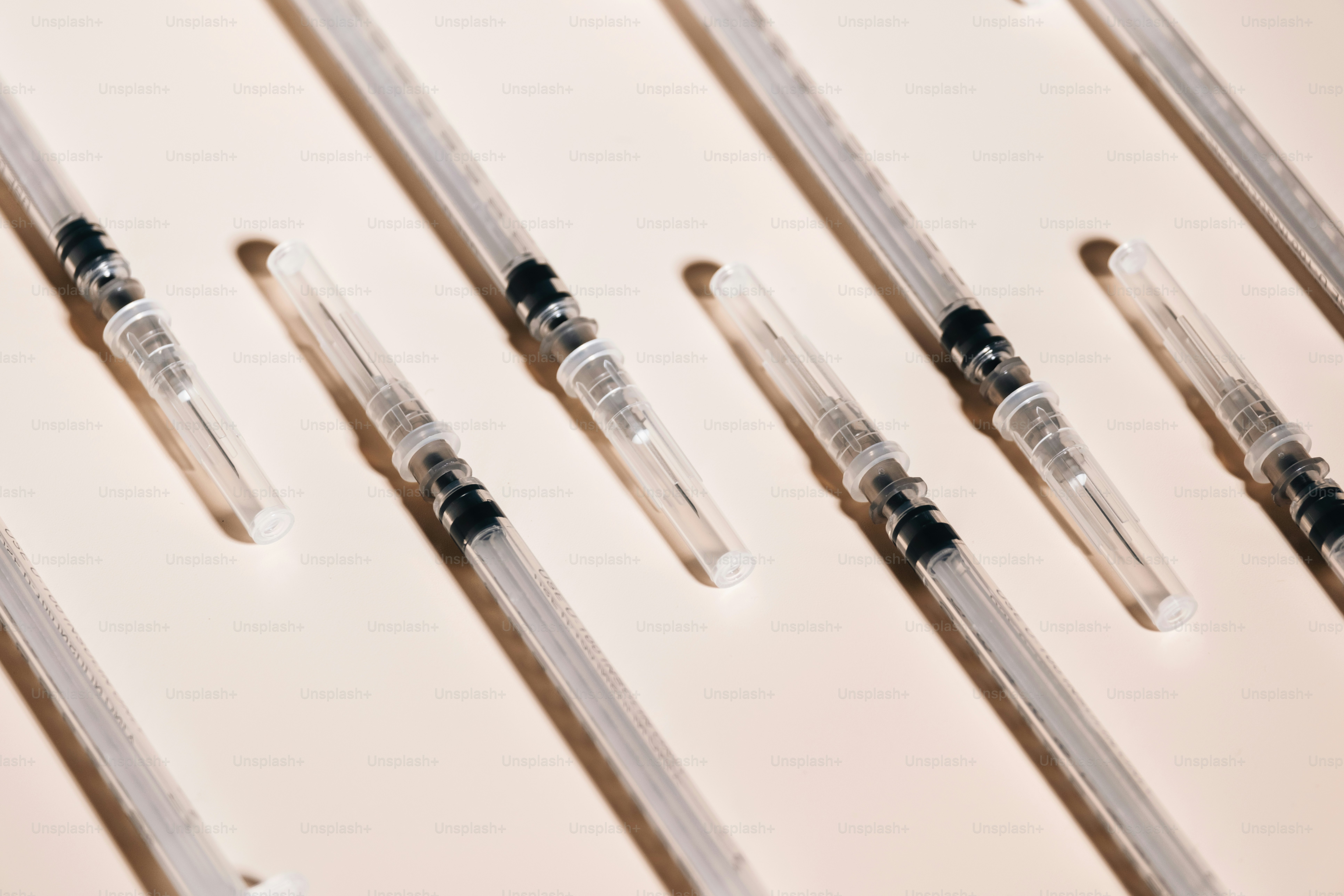 As seringas são colocadas em uma superfície de cor clara.