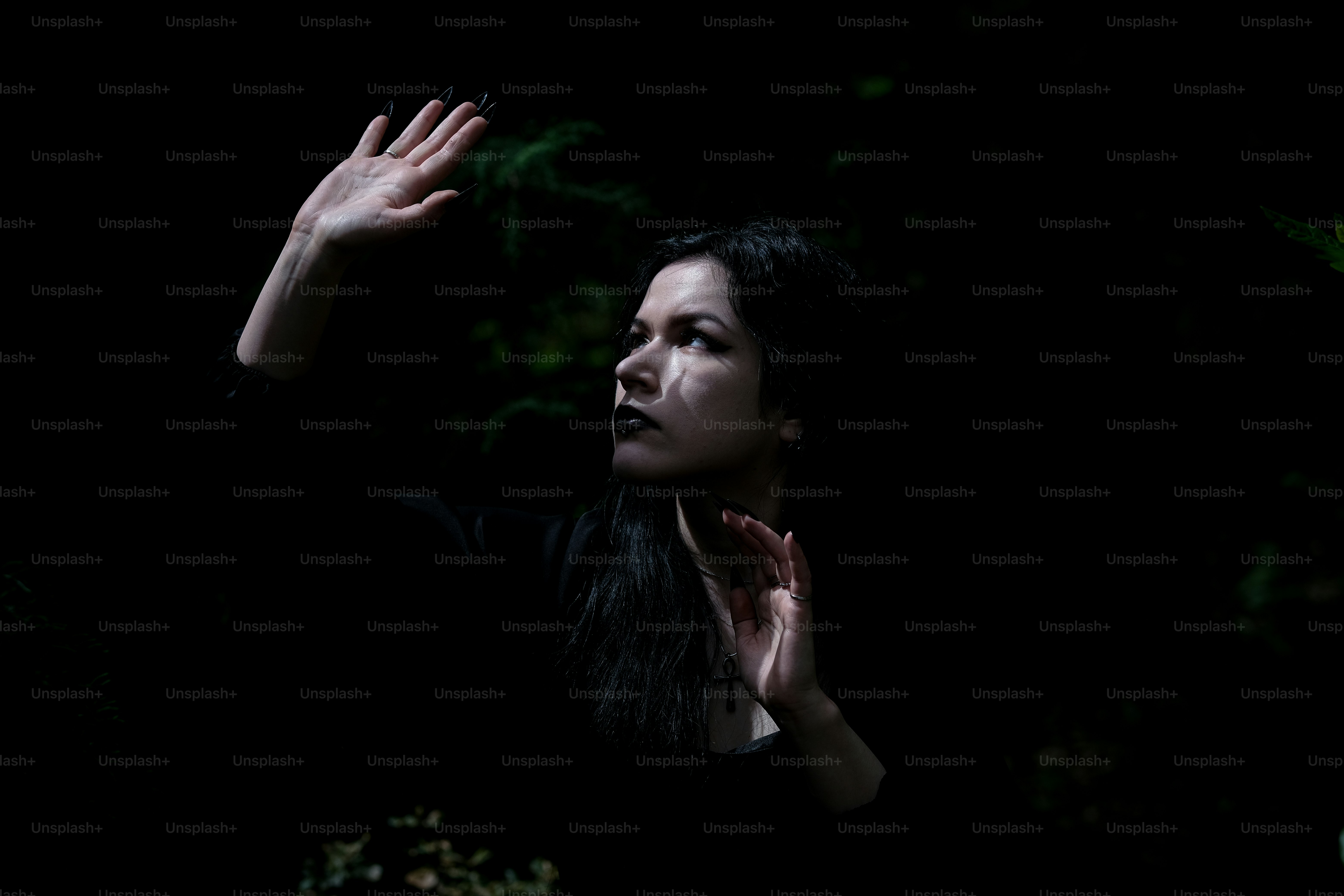 Rosto e mãos de mulher nas sombras.