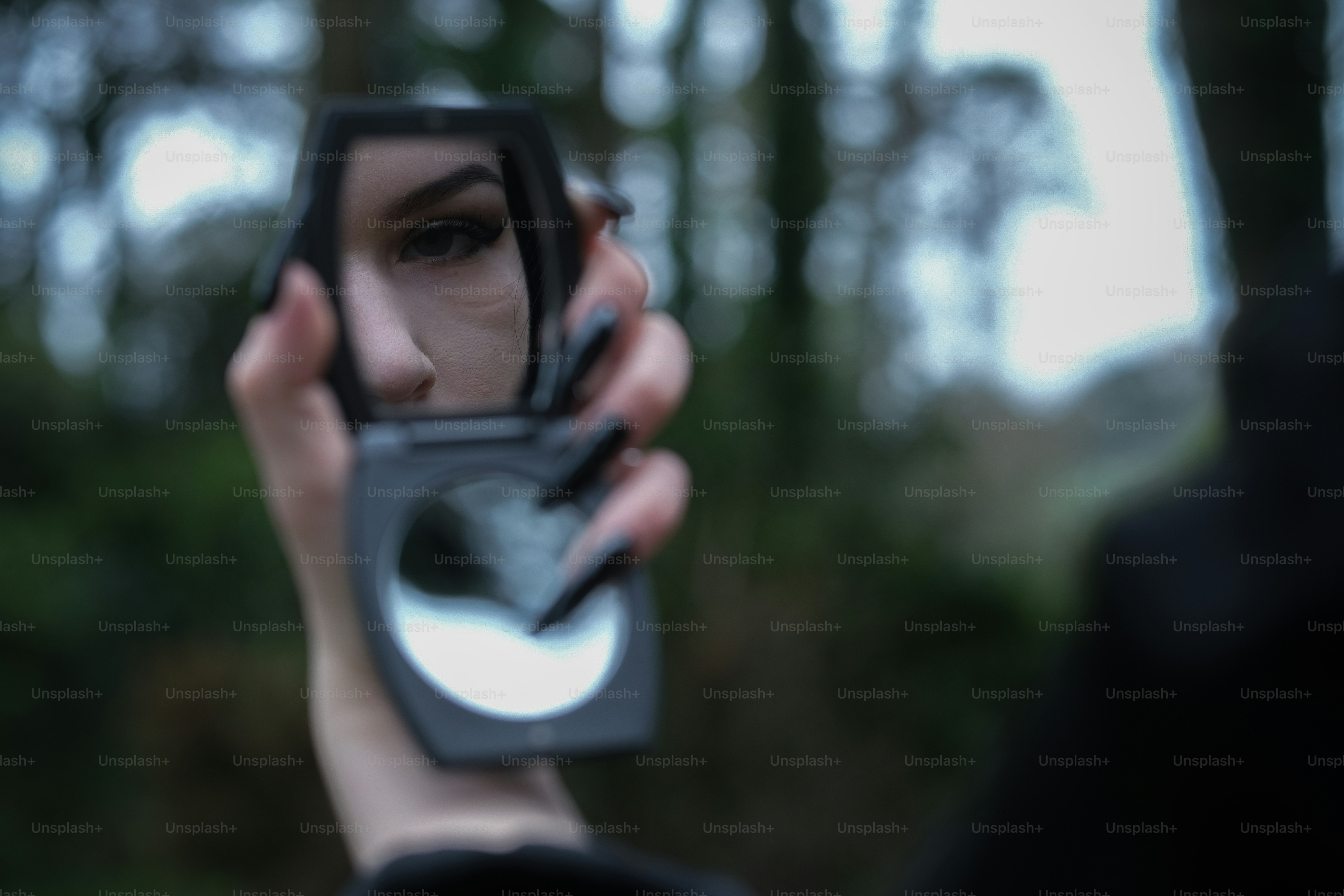 Uma pessoa olha para um espelho ao ar livre.