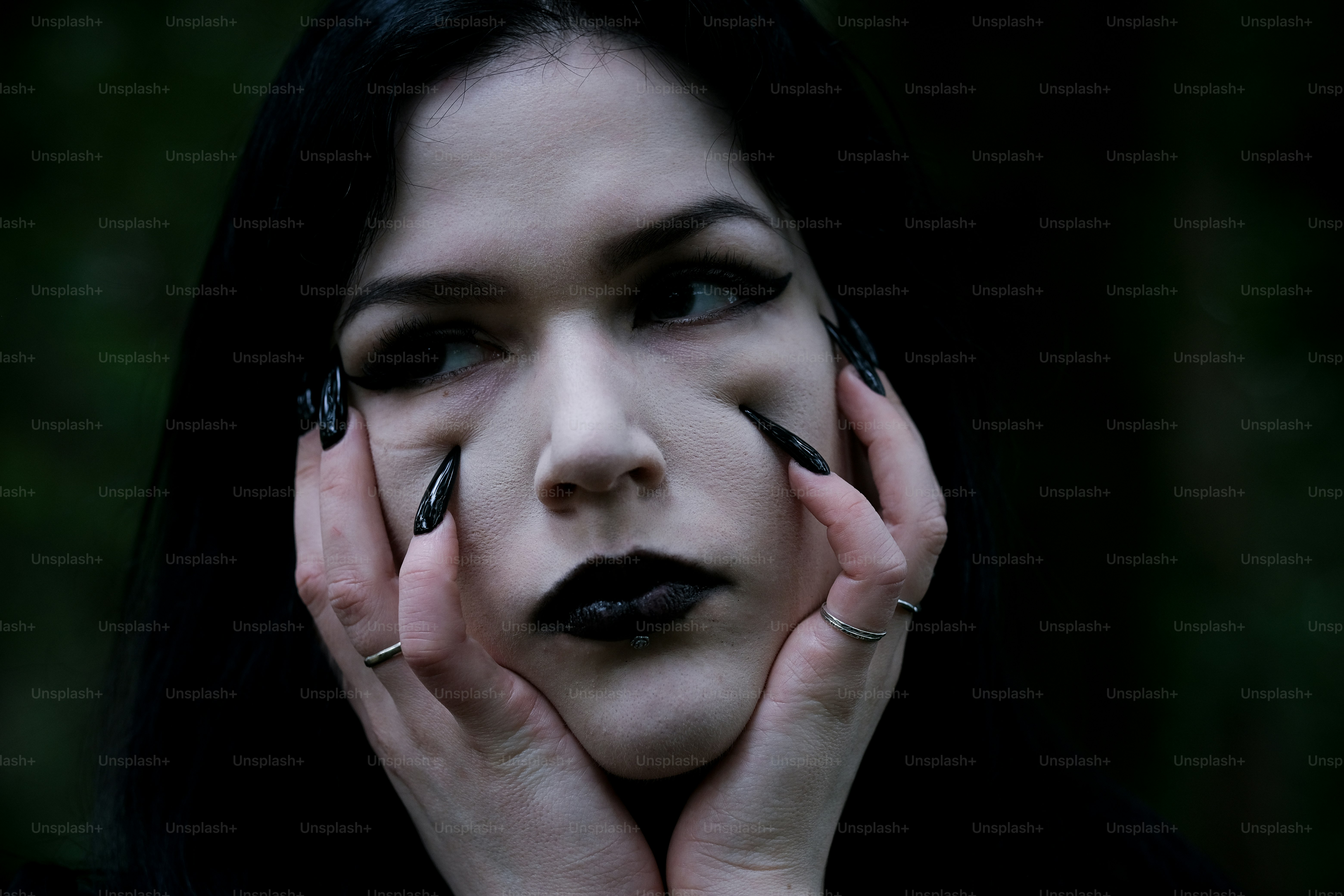 Uma mulher gótica olha pensativa para longe.