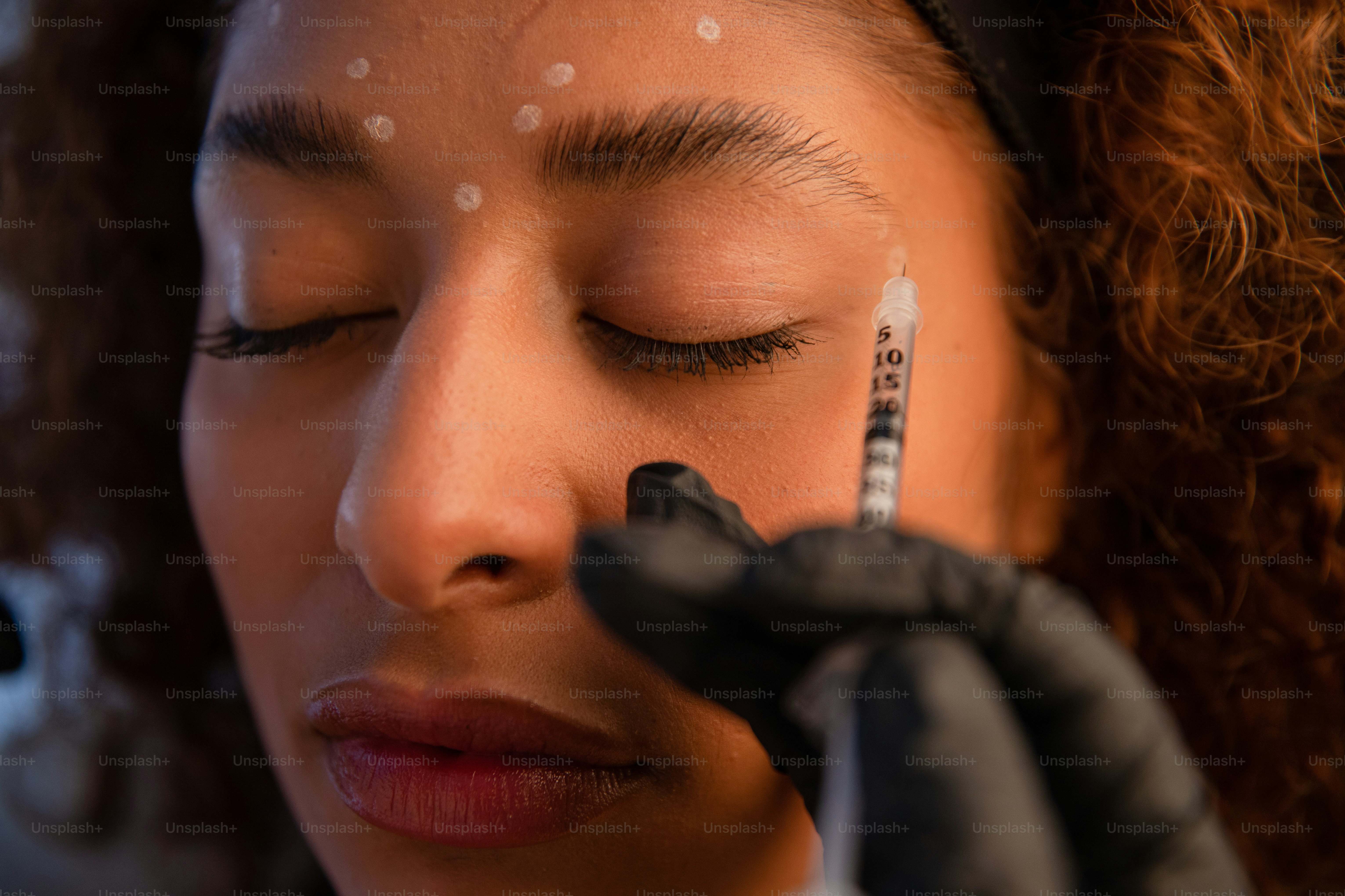 A woman gets an injection in her face. photo – Health Image on Unsplash