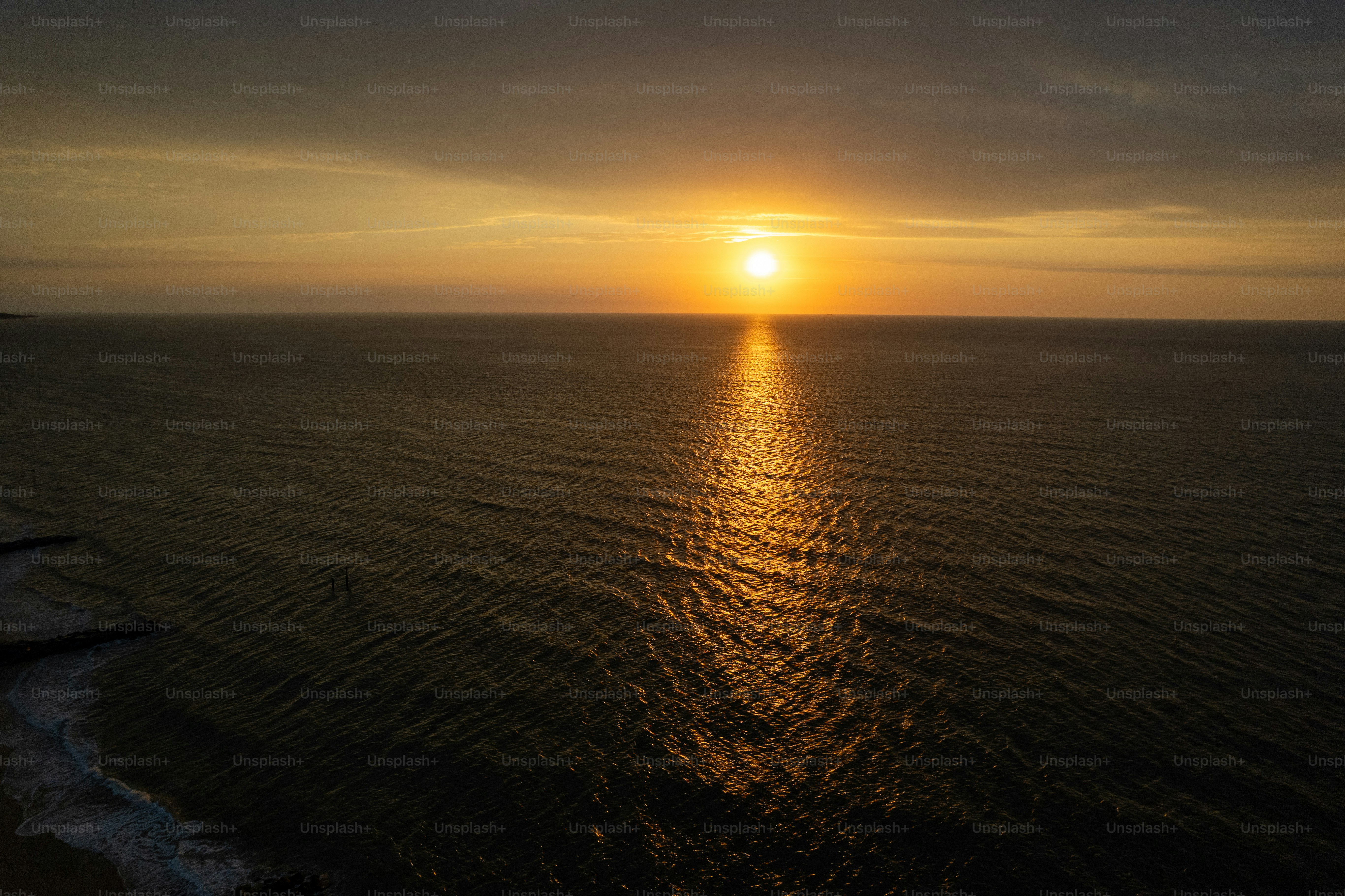 The sun sets over a calm ocean.