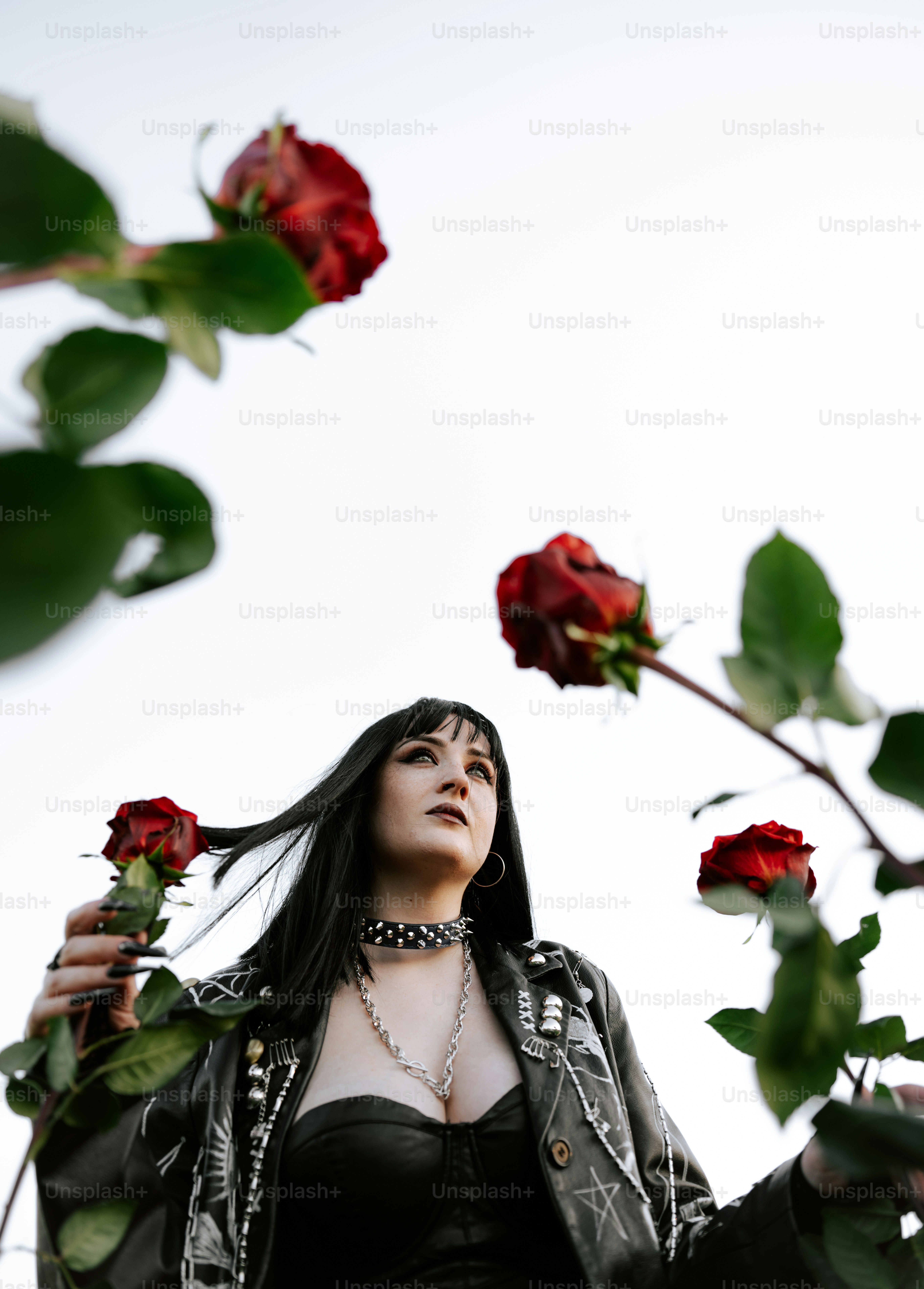 A woman poses with red roses.