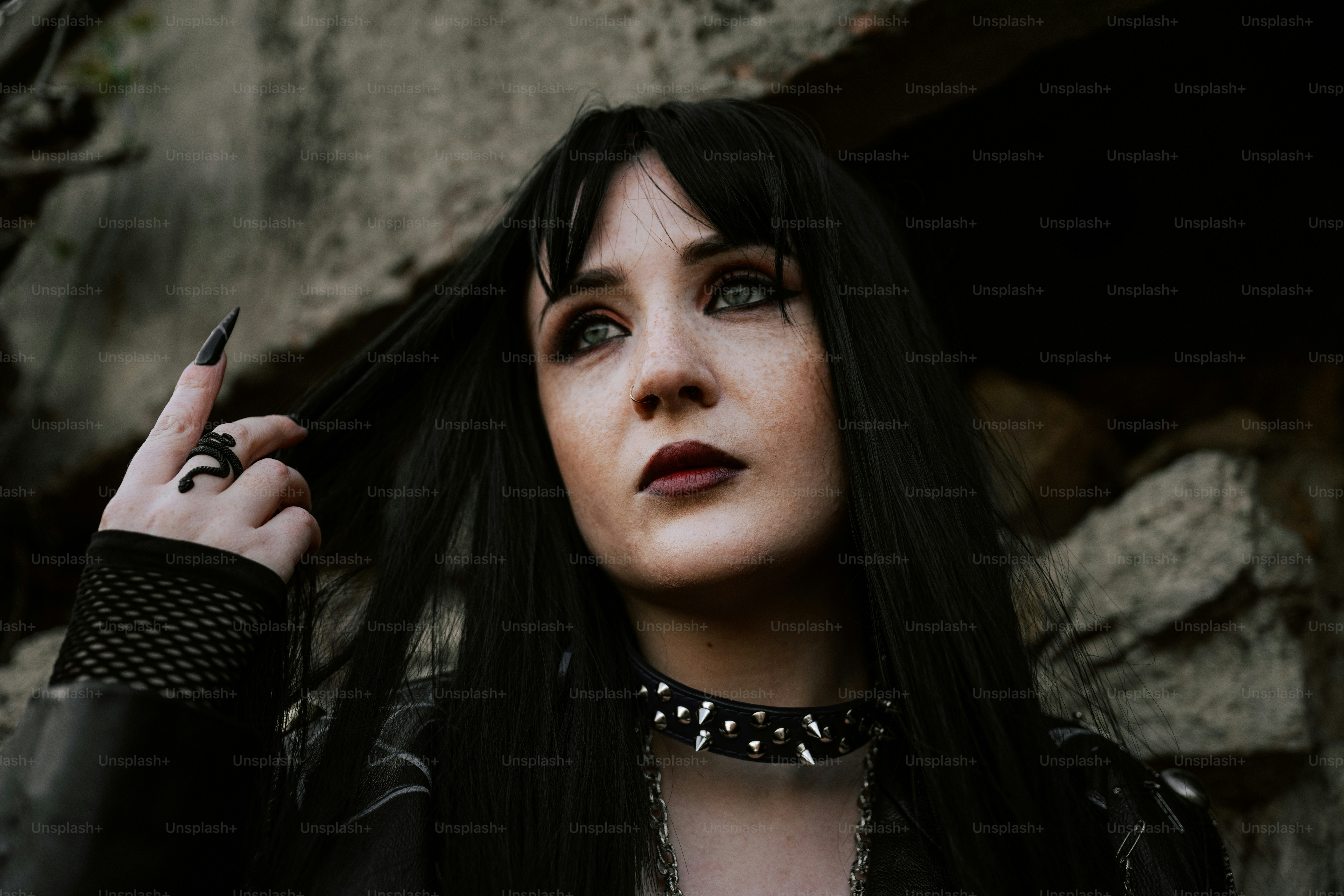 A gothic woman looks up, adorned in black.