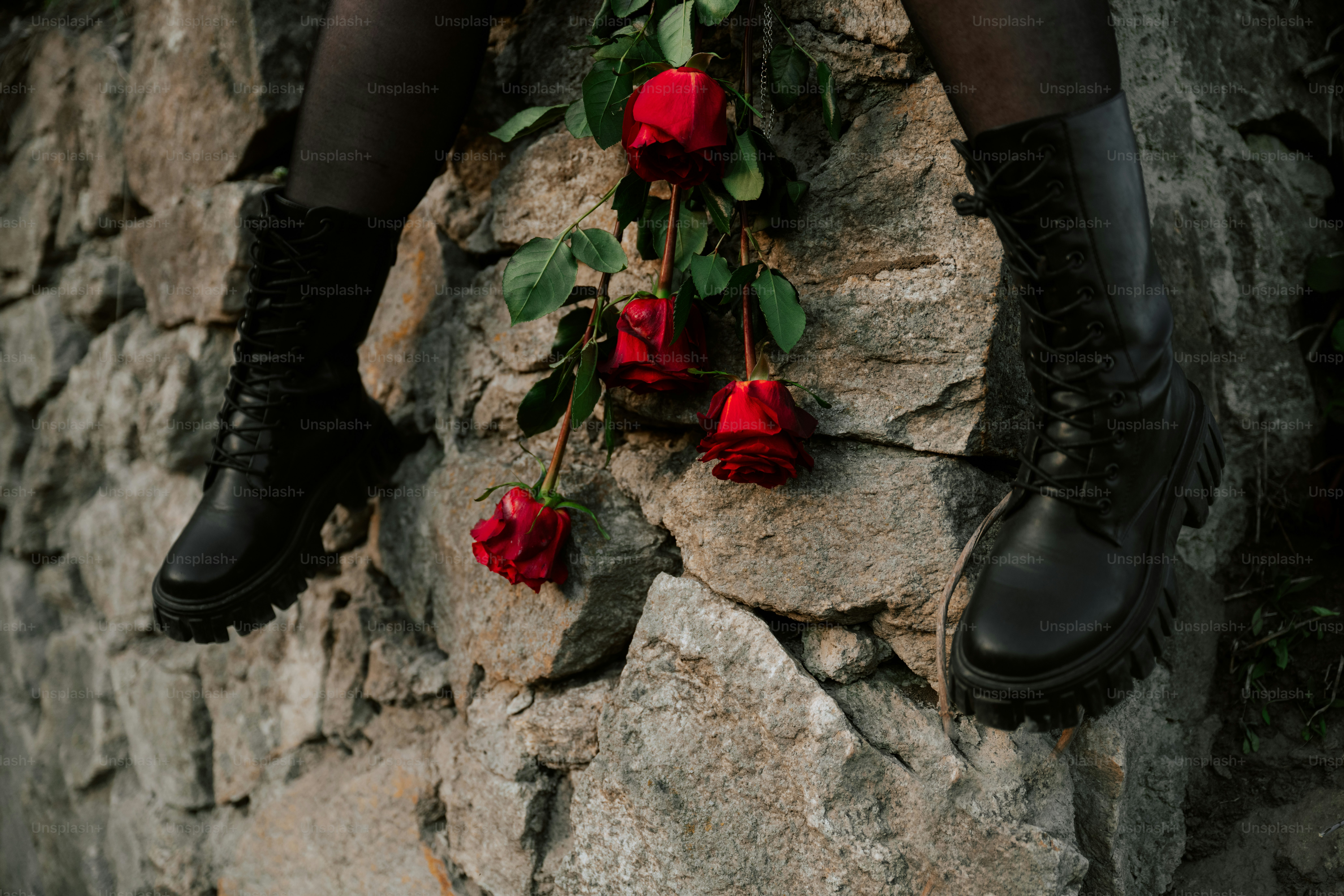 Boots, roses, and a stone wall.