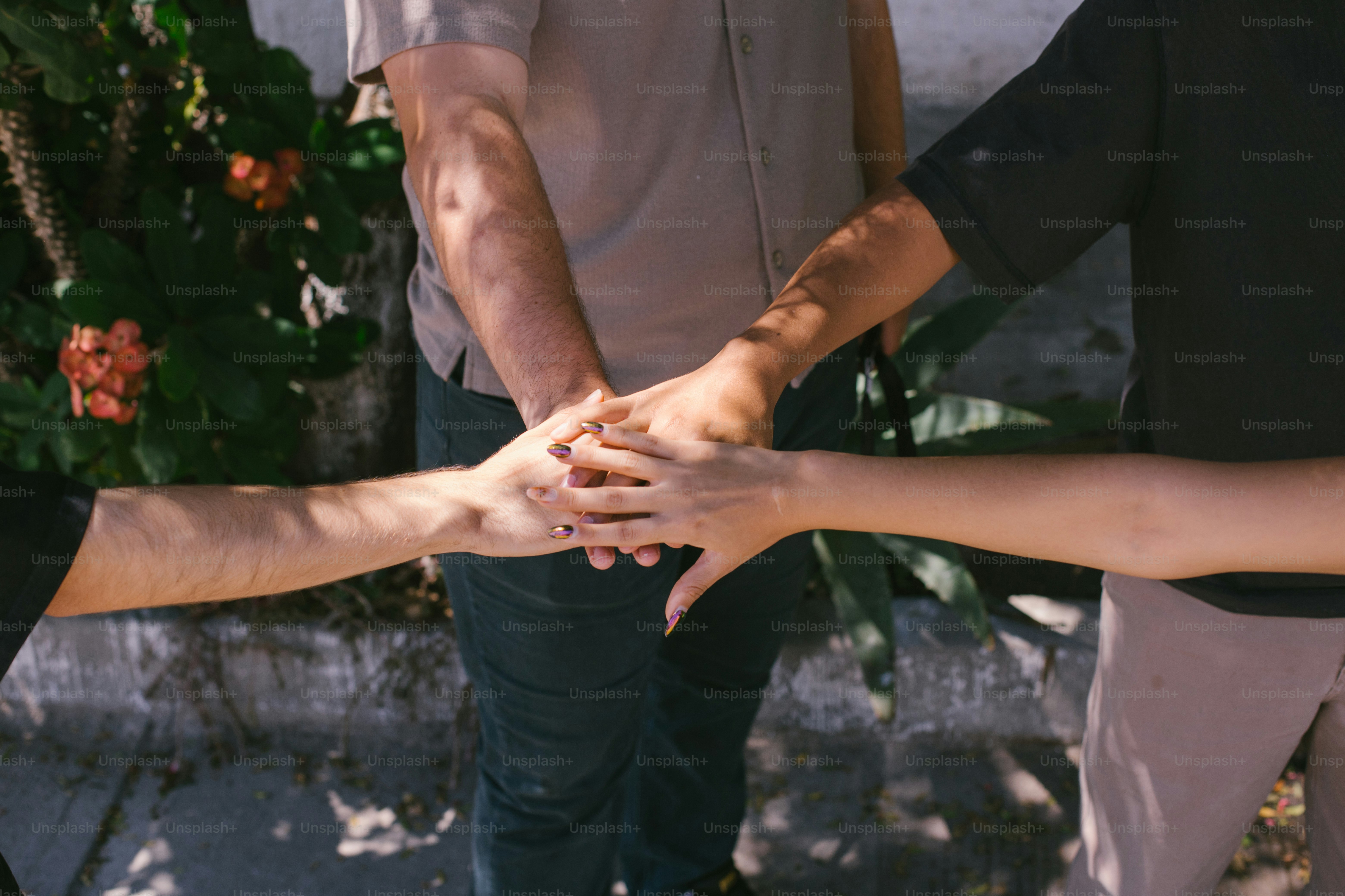 Teamwork is shown through hands stacked together.