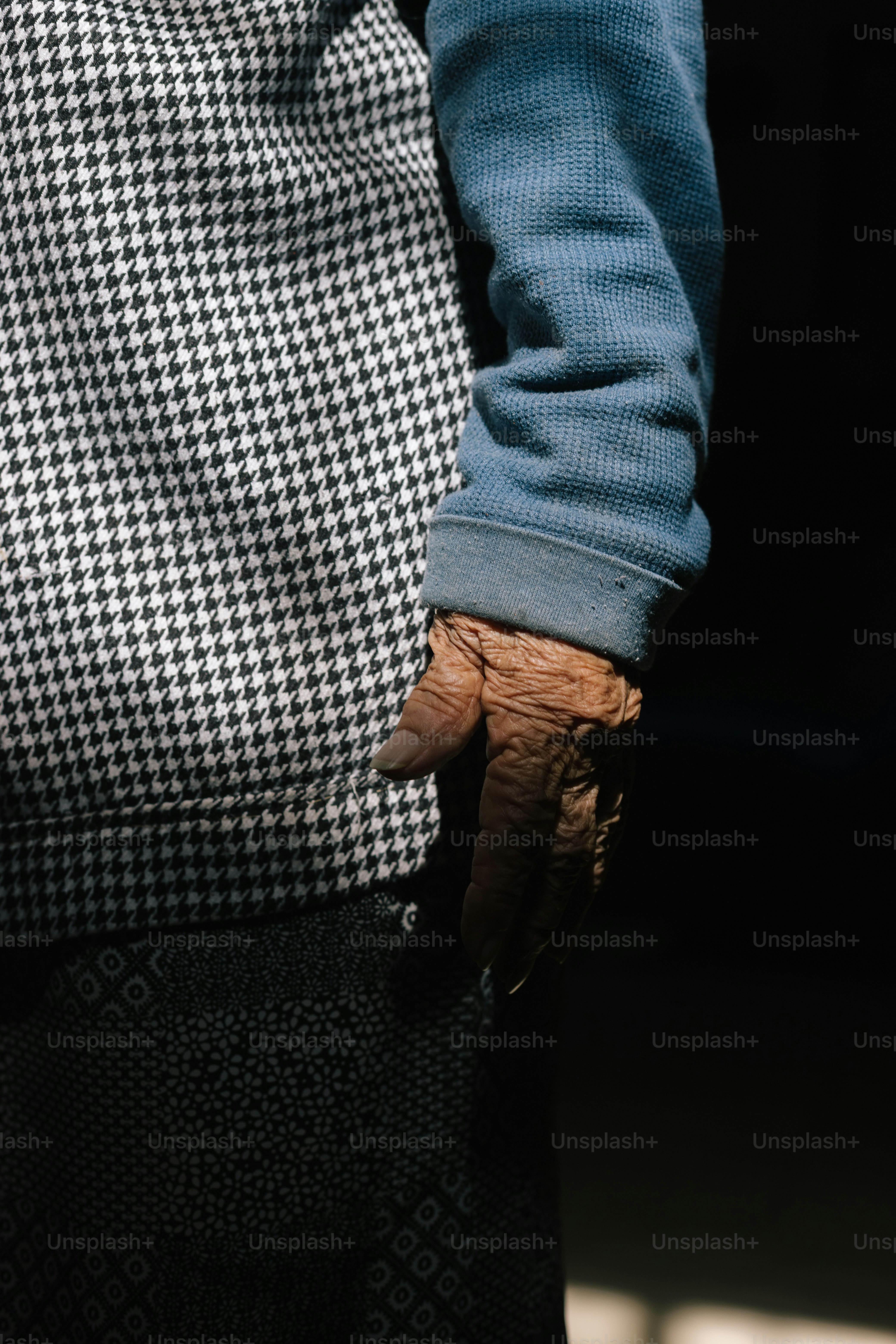 Una mano anciana descansa en un espacio poco iluminado.