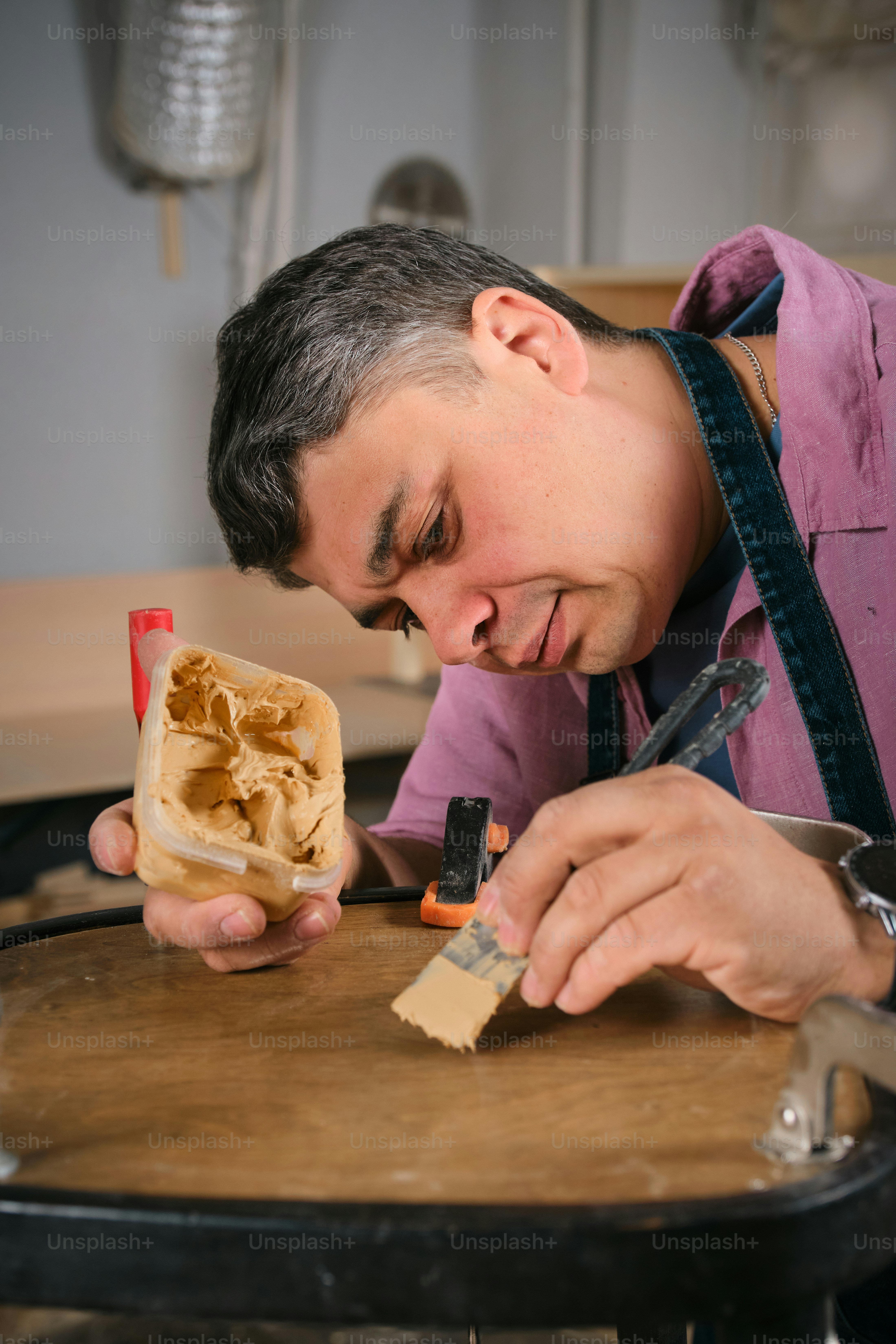 A man is repairing wood with paste.