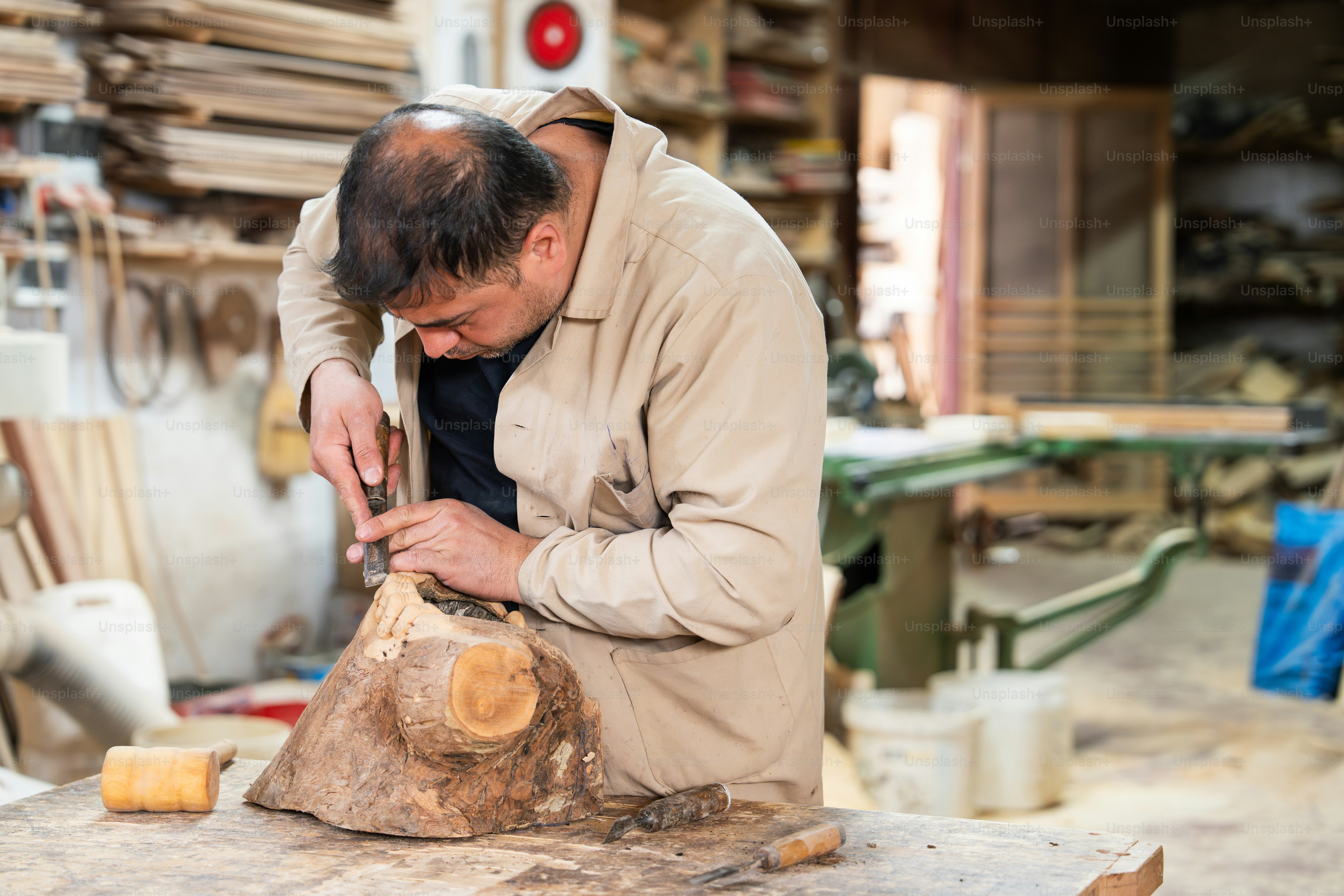 A carpenter is shaping wood with a draw knife. photo – Wood Image on ...