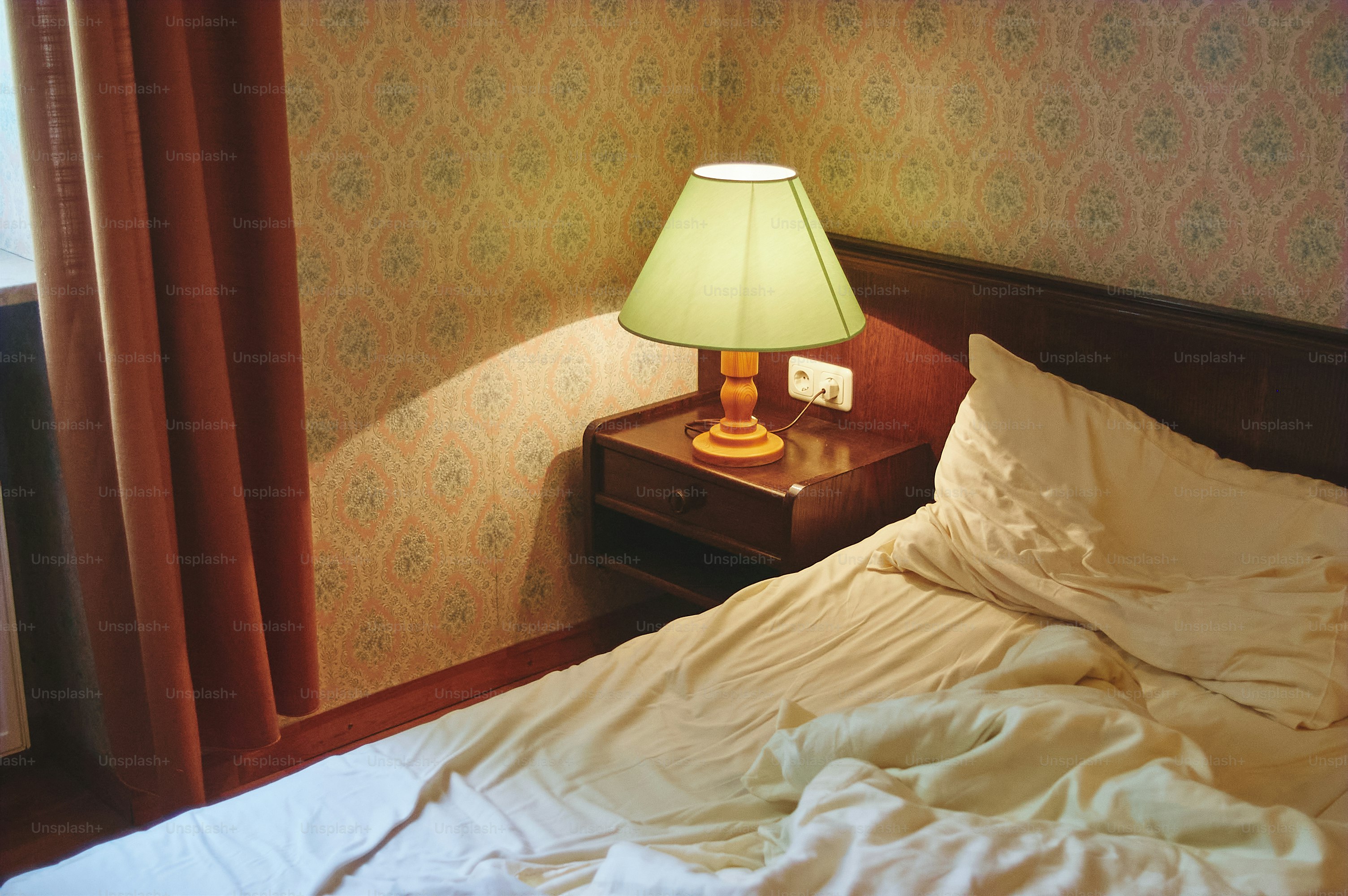 Ein Bett mit einer Lampe befindet sich in einem Hotelzimmer.