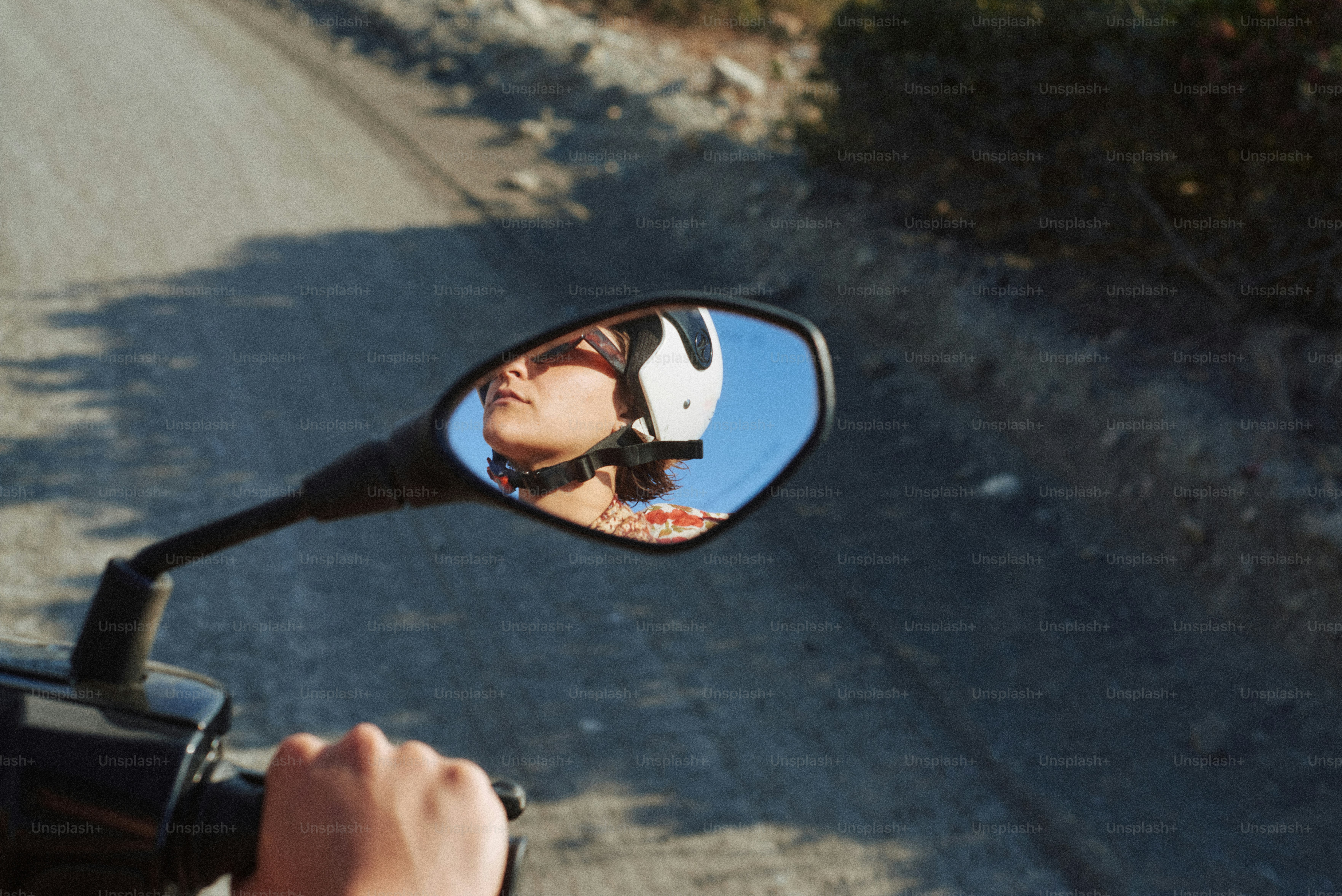Person reflected in a motorcycle's side mirror.