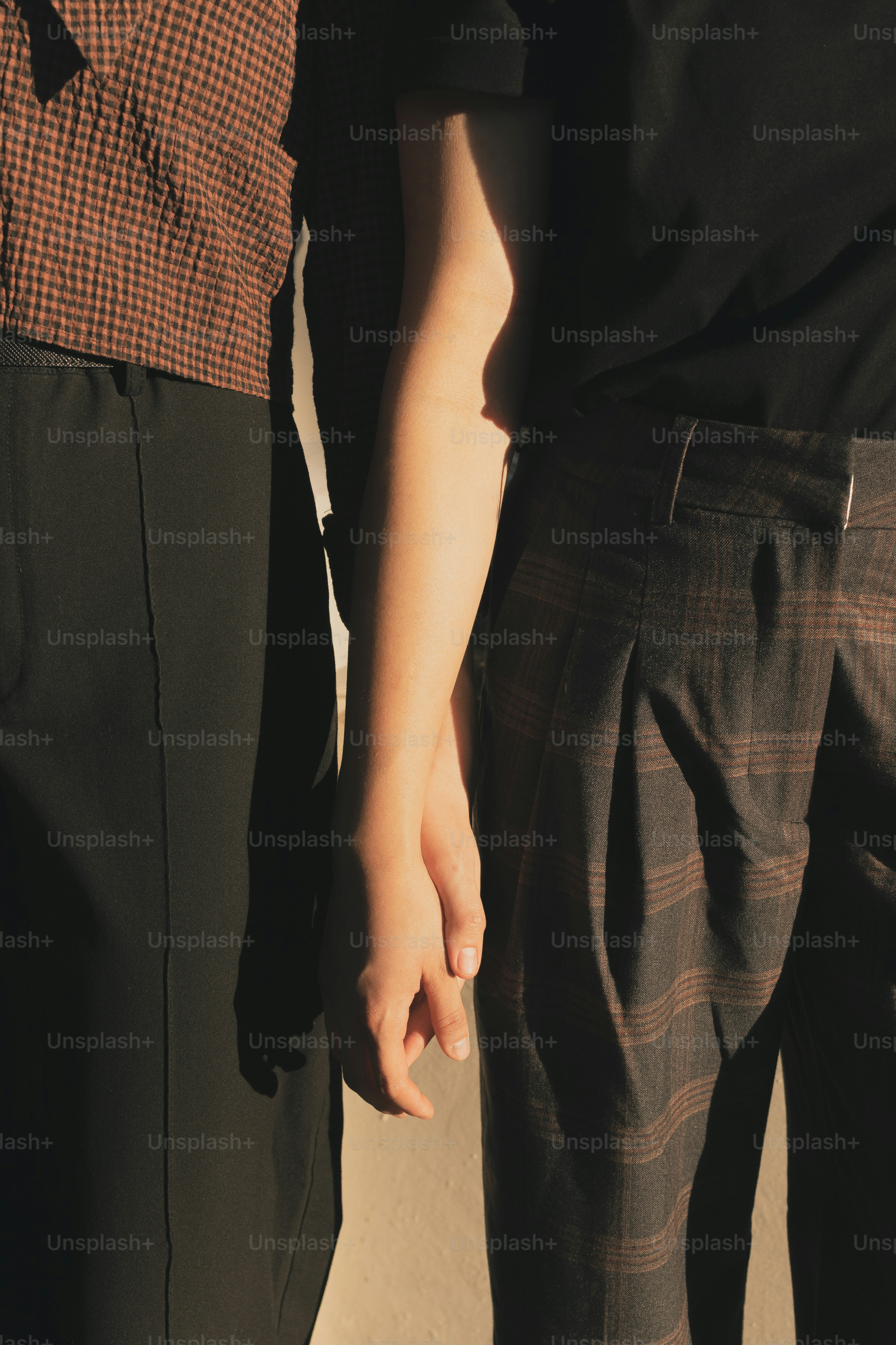 Zwei Menschen halten sich an den Händen.