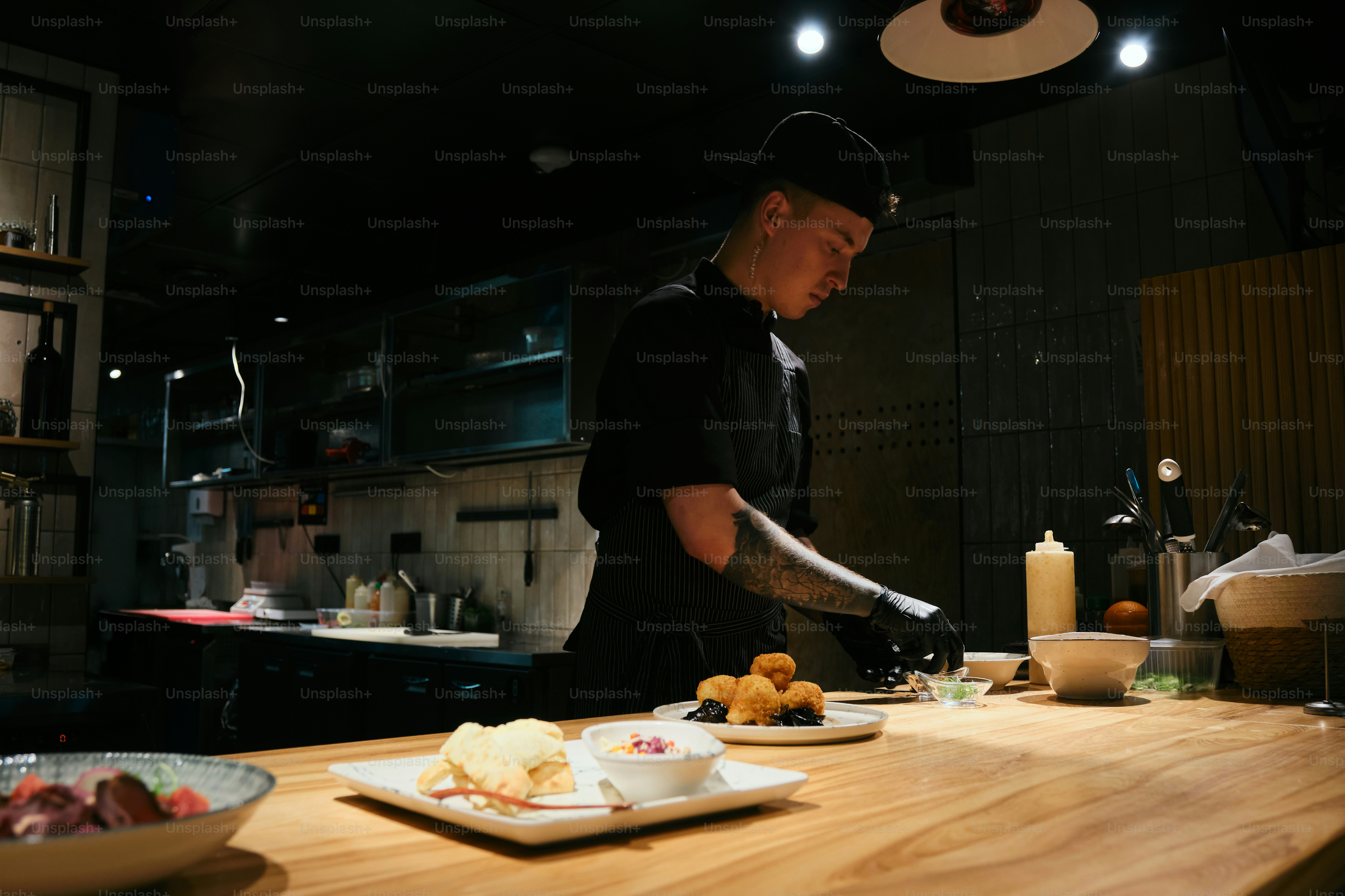 A chef prepares food in a dimly lit kitchen.