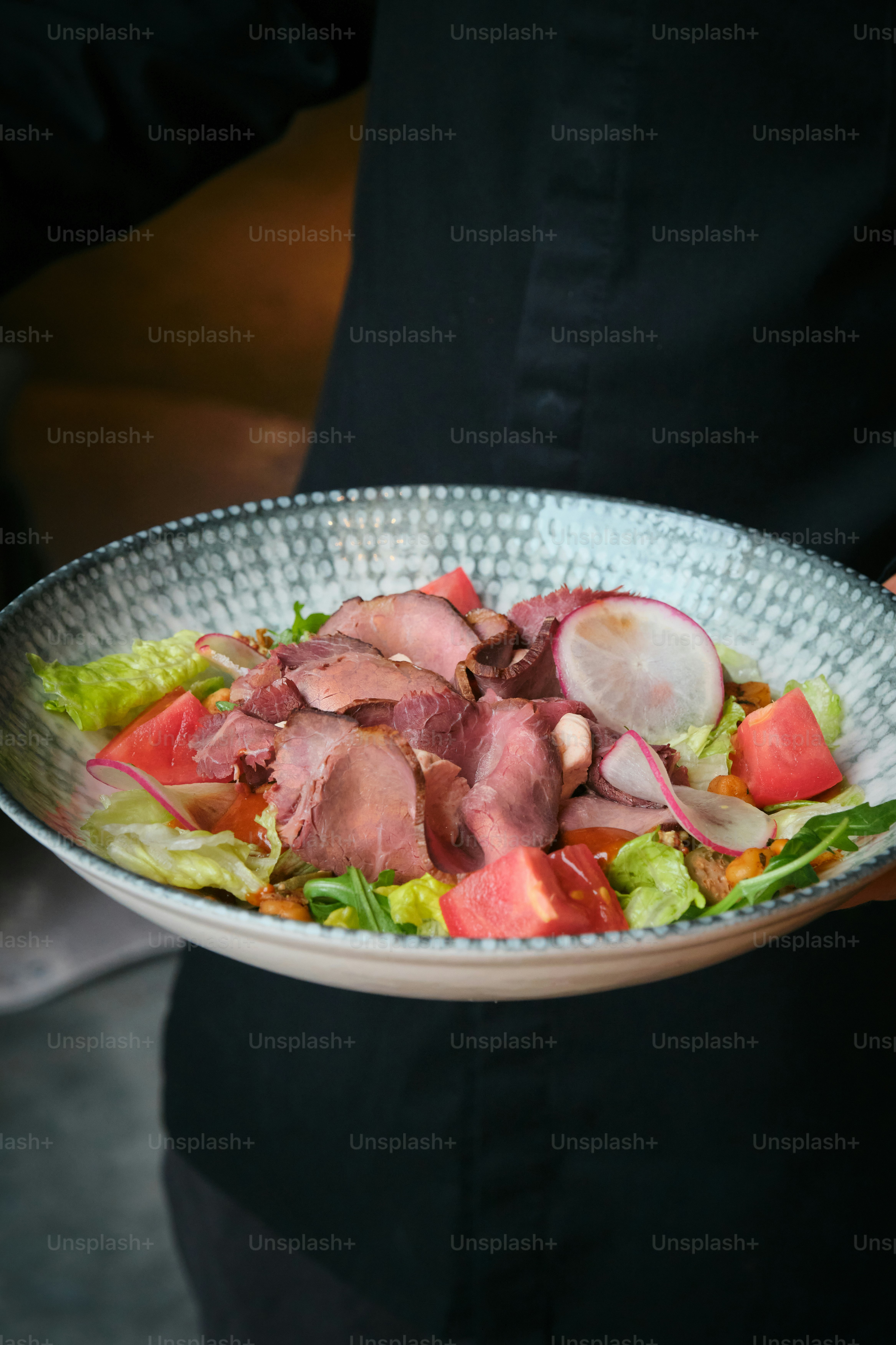 Someone is holding a delicious-looking salad.