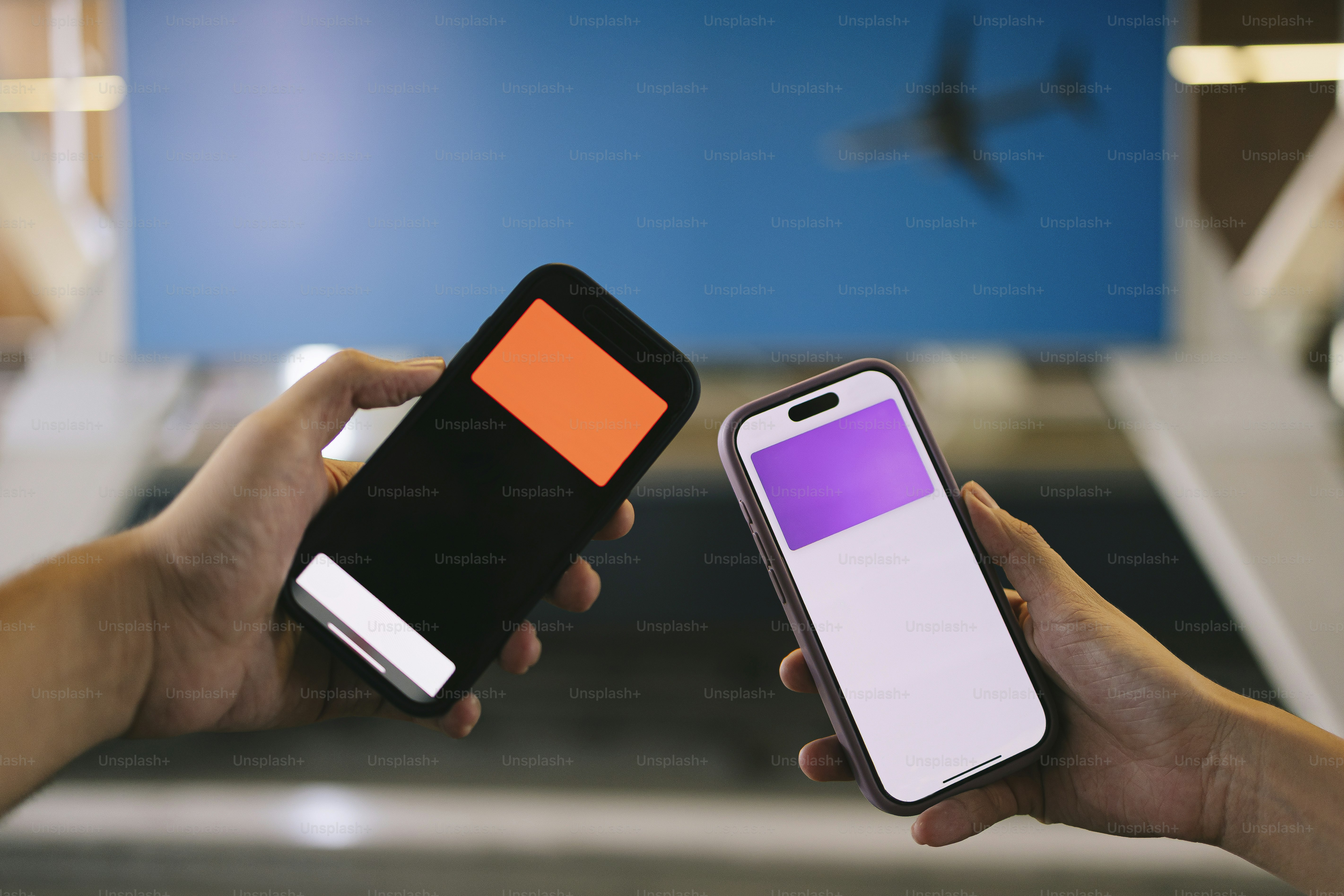 Dois telefones são erguidos, mostrando uma tela cada.