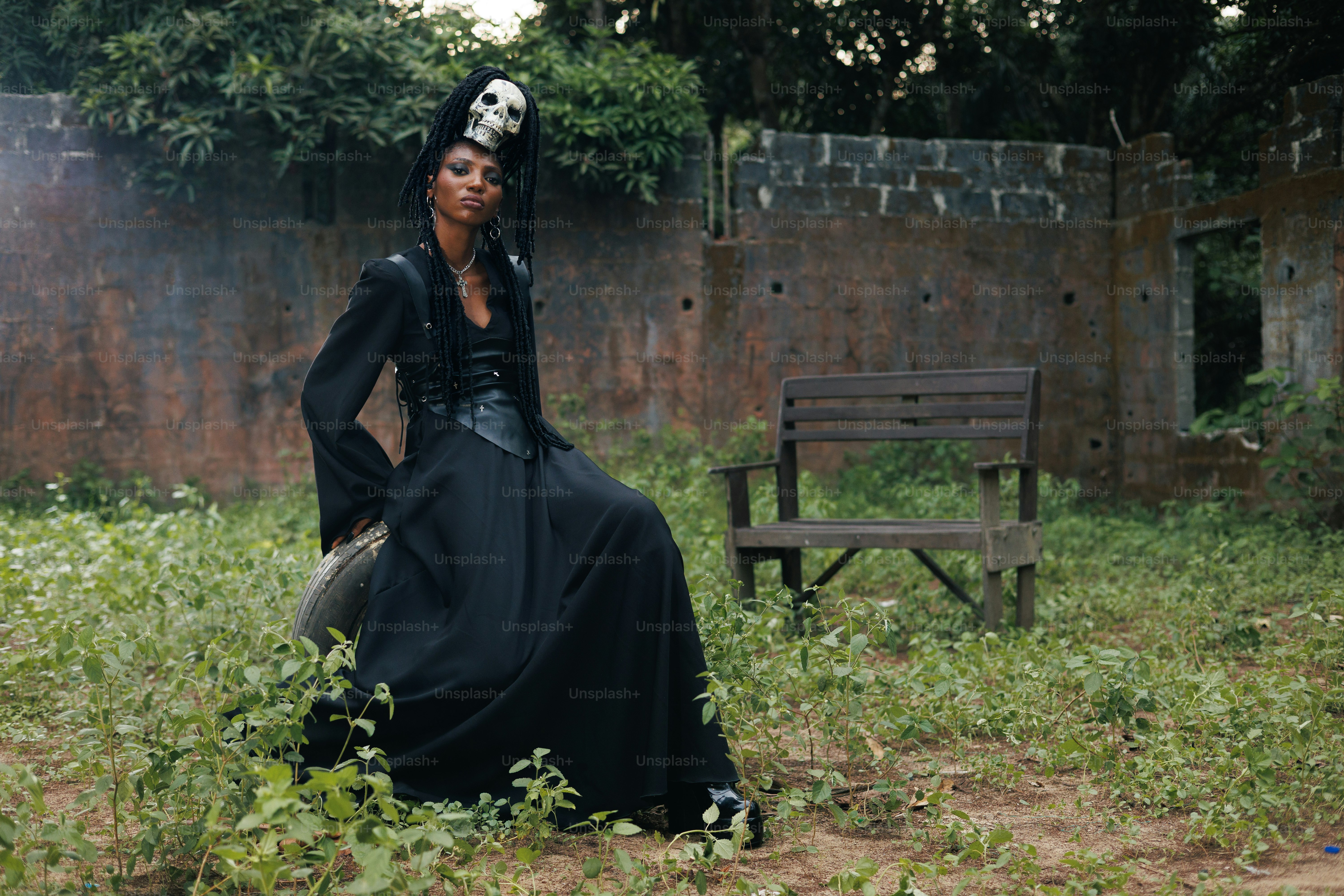 A person in black clothing and skull headdress.