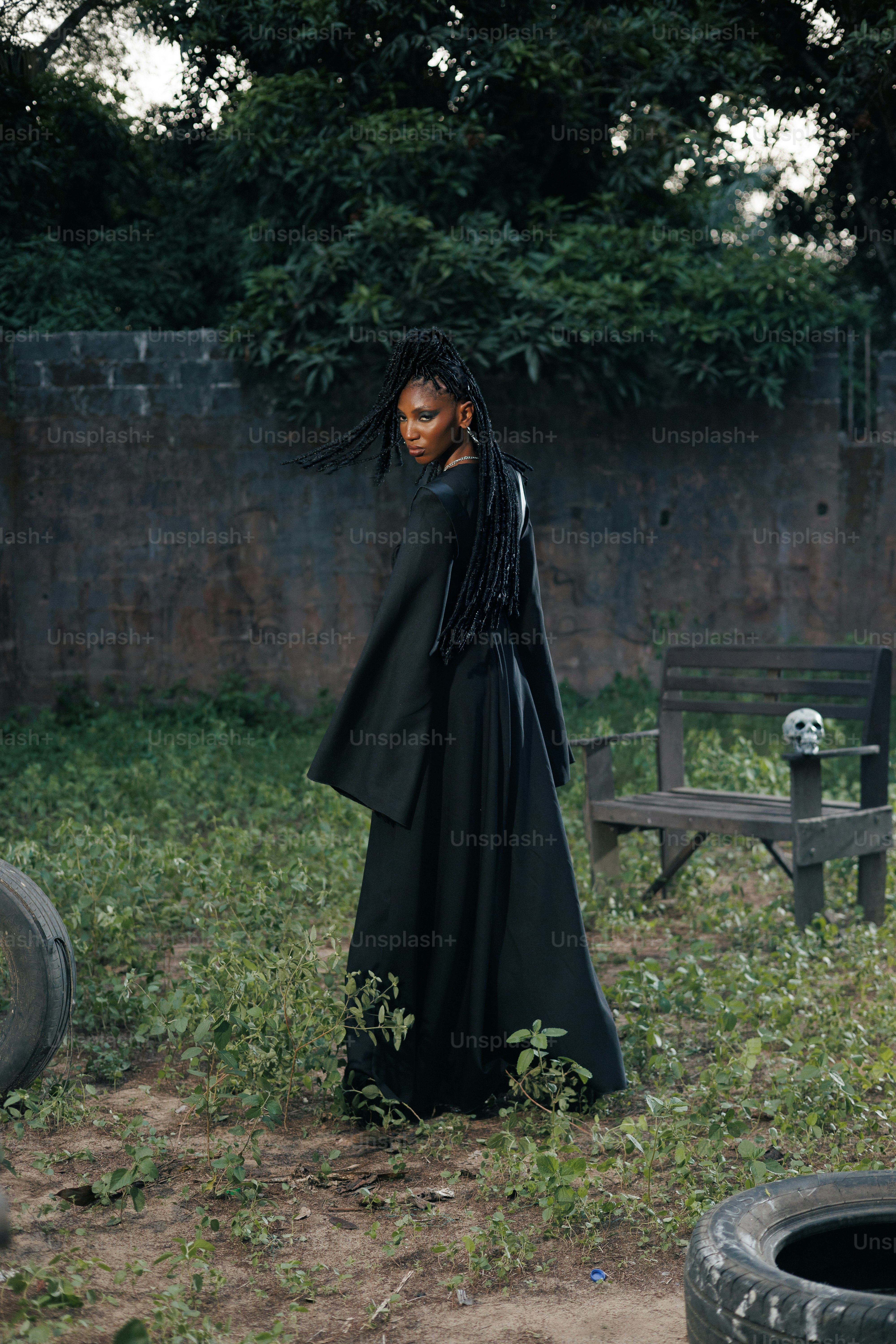 A woman poses in a long black dress.