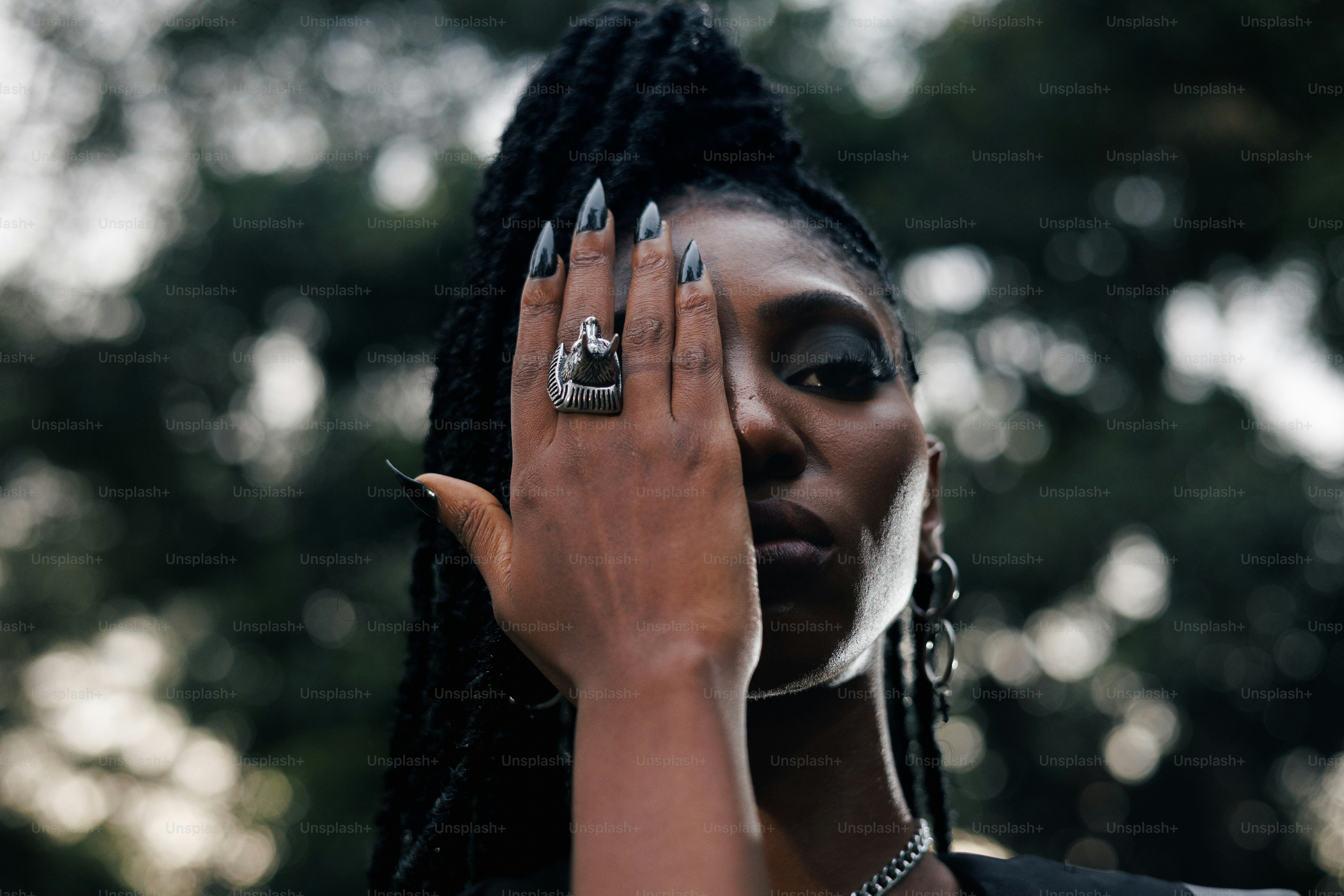 A woman covers her eye with a decorated hand.