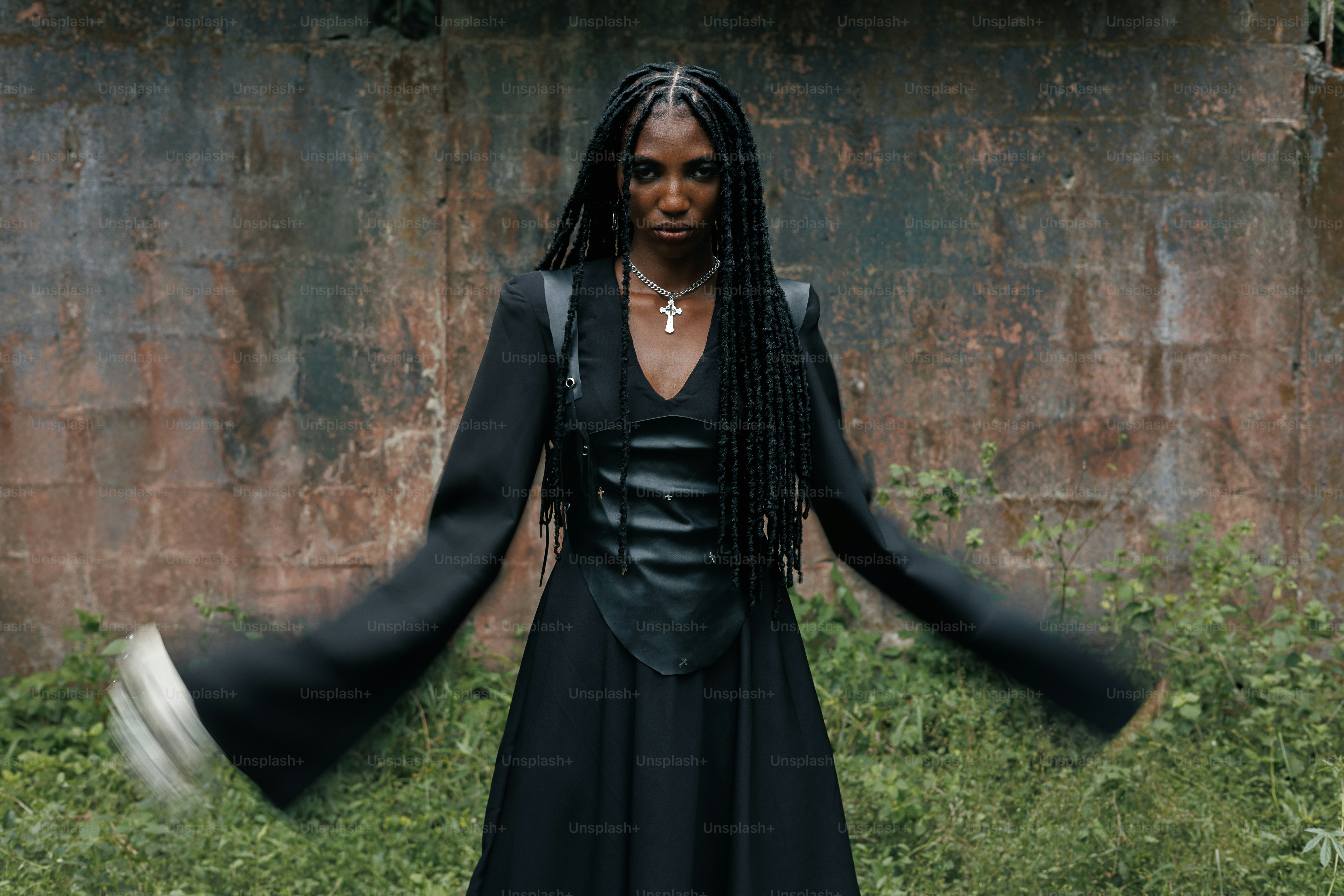 Woman poses in front of a brick wall.