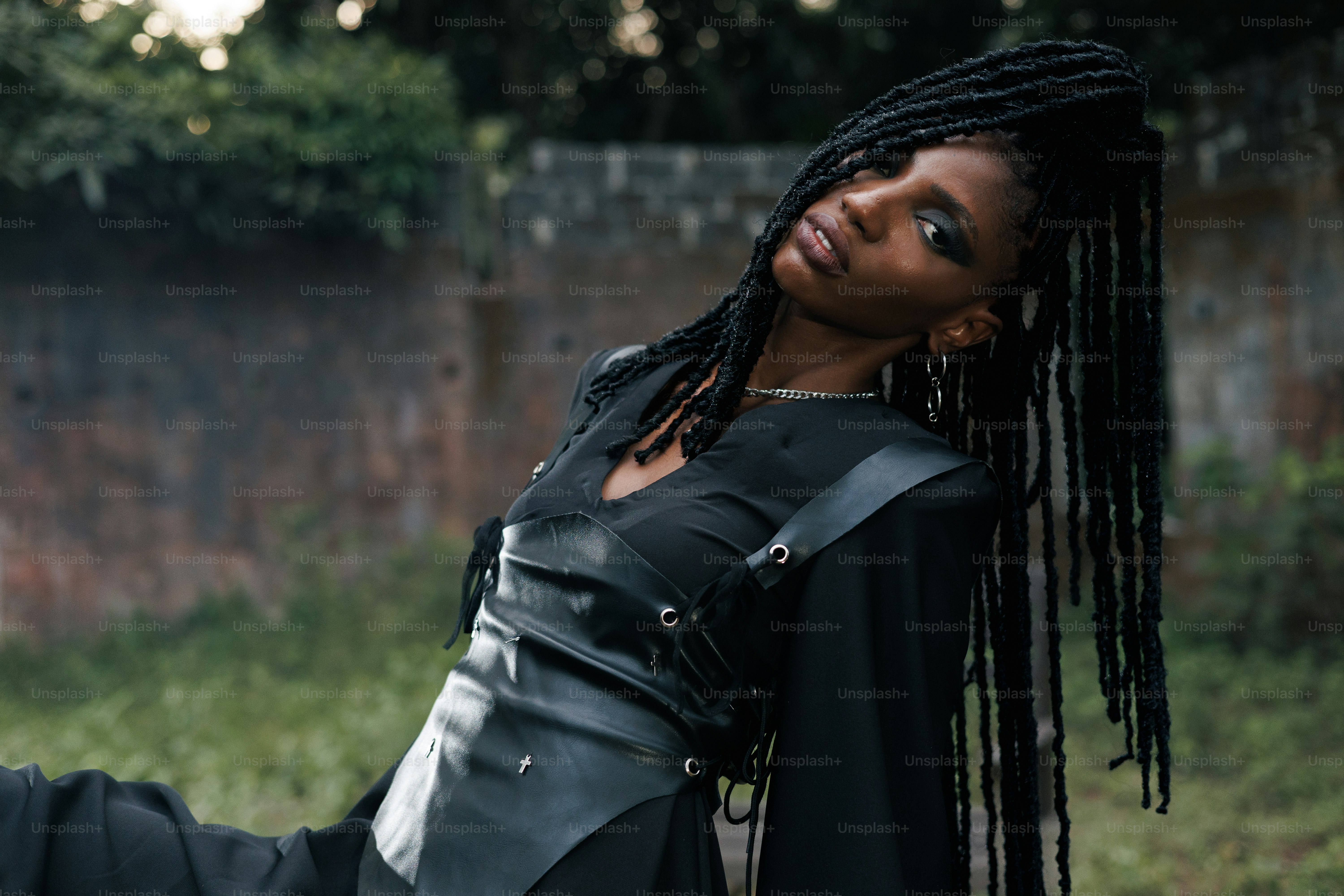 A stylish woman poses in an outdoor setting.